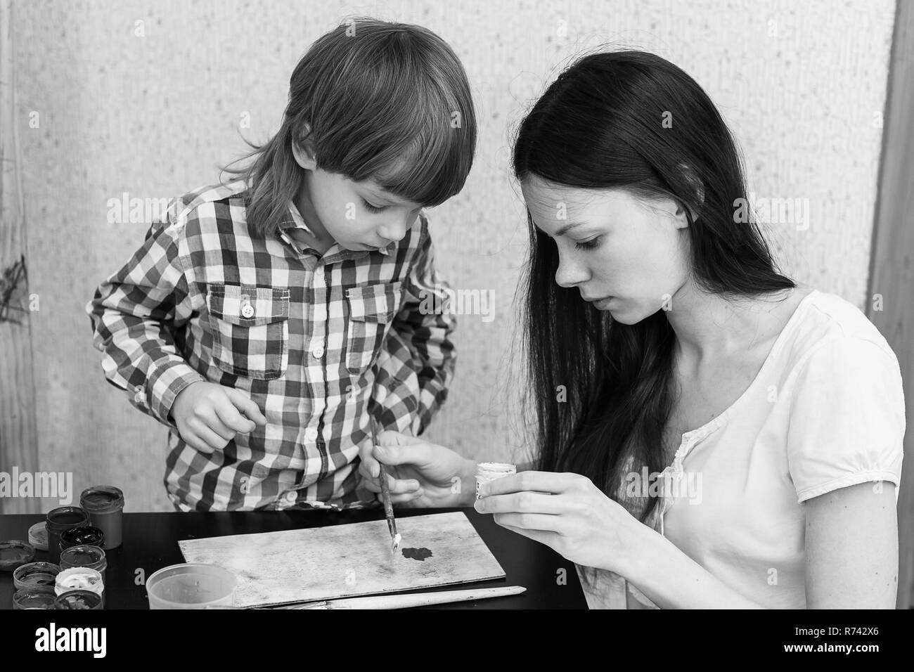 Jeune belle mère fils avec les garçons à la maison les couleurs de peinture. Fils à Maman enseigne les couleurs. Banque D'Images