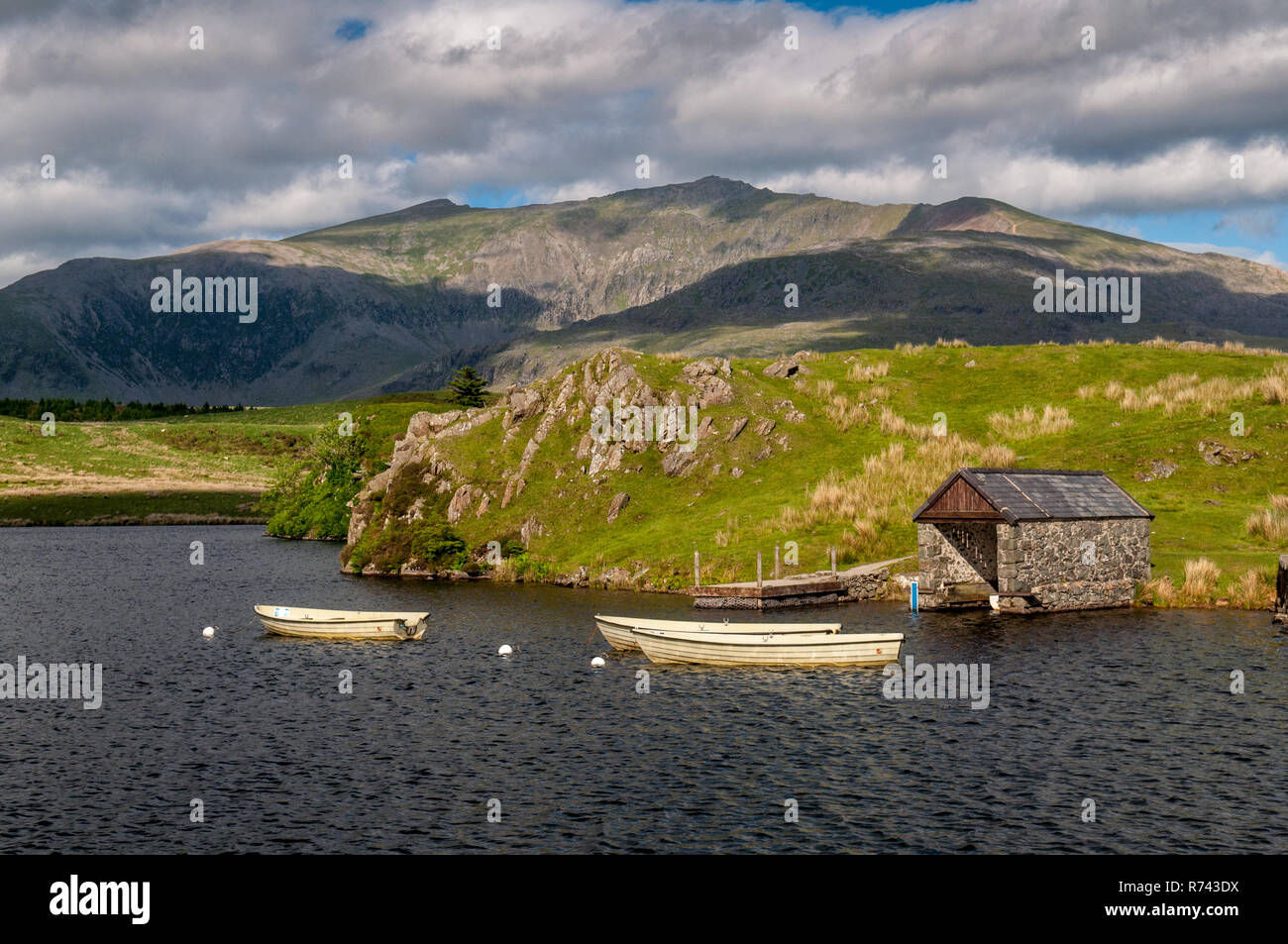Bateaux amarrés sur un petit lac près de Rhyd Ddu, avec Snowdon Mountain derrière, dans le parc national de Snowdonia dans le nord du Pays de Galles. Banque D'Images
