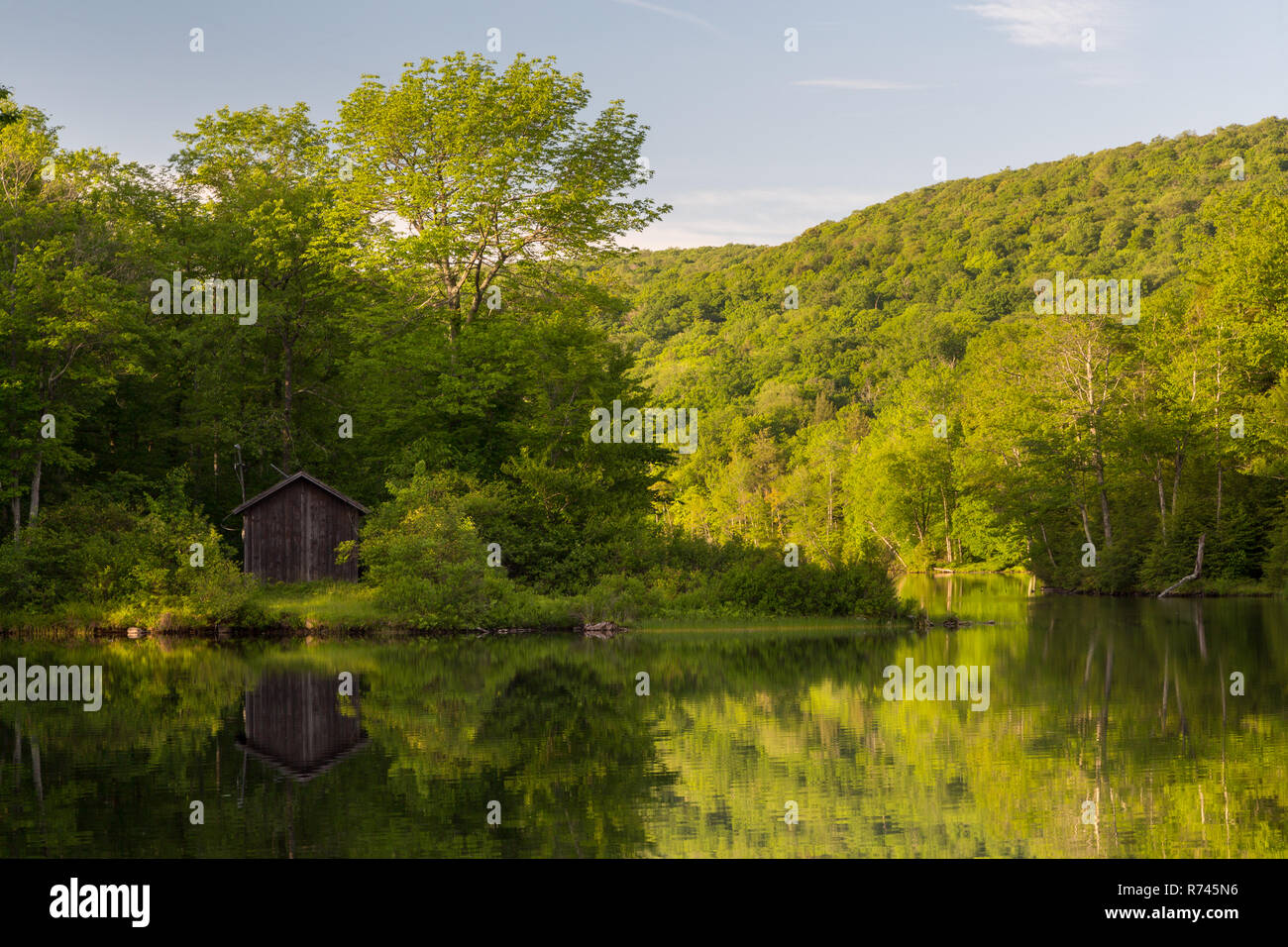 Une remise d'utilité reflète dans les eaux calmes de Mongaup Pond. Mongaup Pond Campground, New York Banque D'Images