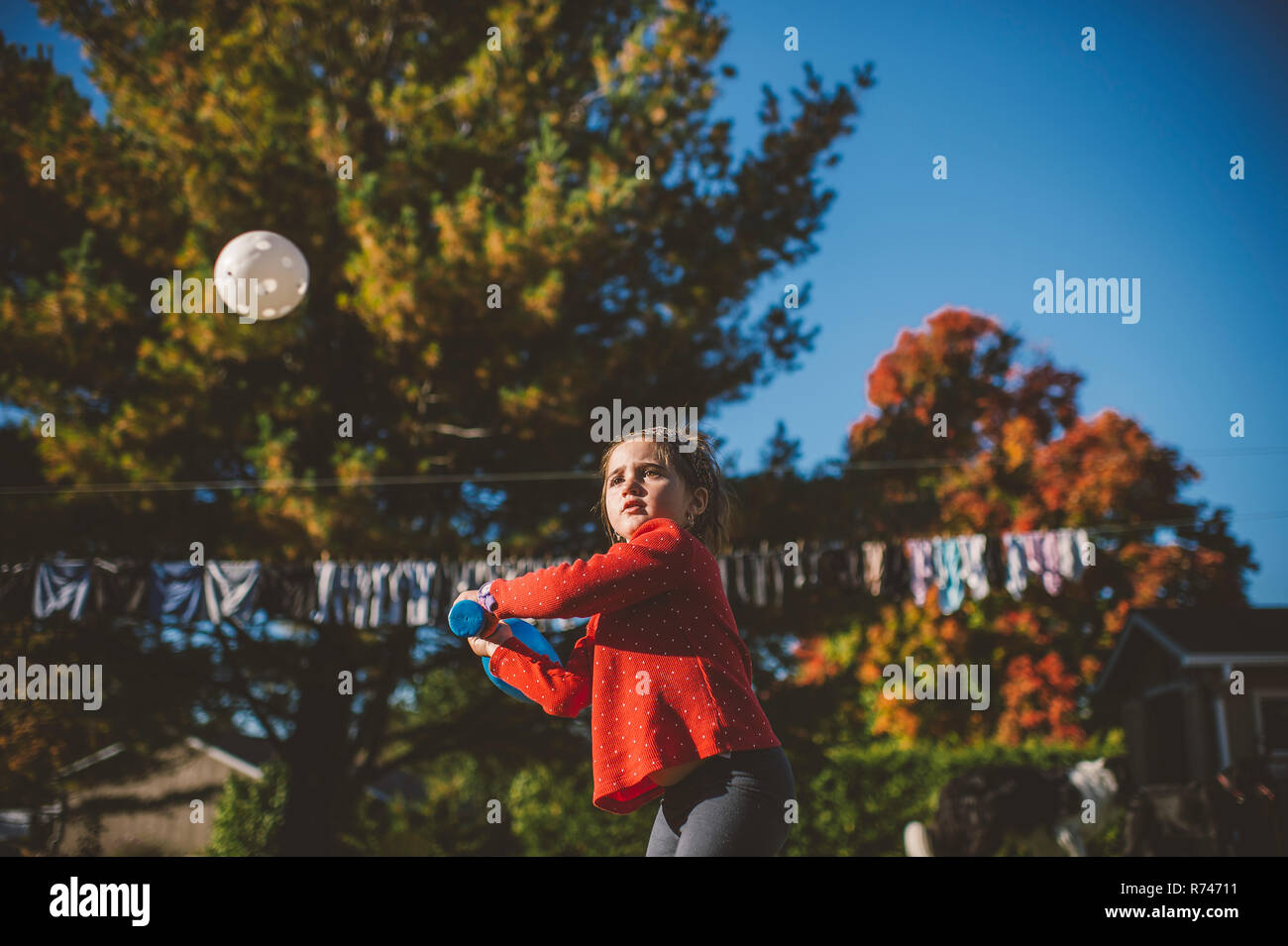 Girl preparing to hit ball Baseball in garden Banque D'Images