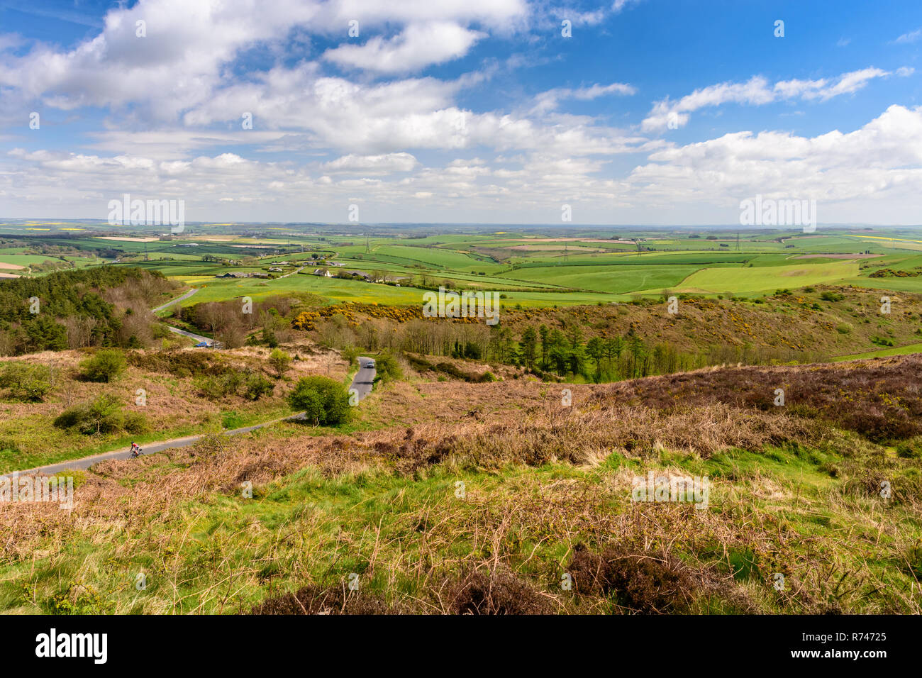 Dorchester, England, UK - 16 Avril 2017 : Un cycliste noir clumbs en bas de la colline au-dessus de la Dorchester terres agricoles vallonnées du paysage de l'Angleterre à Dorset Banque D'Images