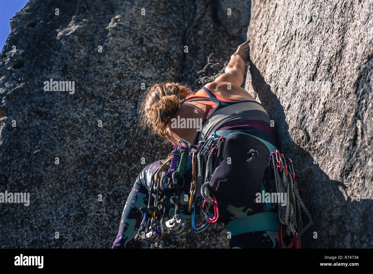 Young female rock climber climbing rock face à la fumée, Bluffs, Squamish, British Columbia, Canada Banque D'Images