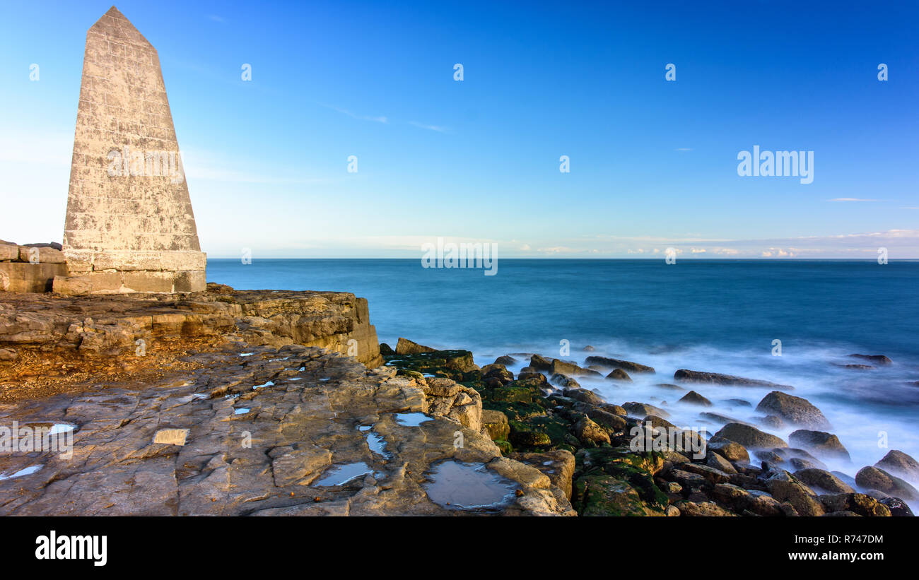 Les vagues déferlent sur la côte rocheuse de la côte jurassique du manche en vertu de la Trinity House obélisque marquant la pointe de Portland Bill dans le Dorset. Banque D'Images