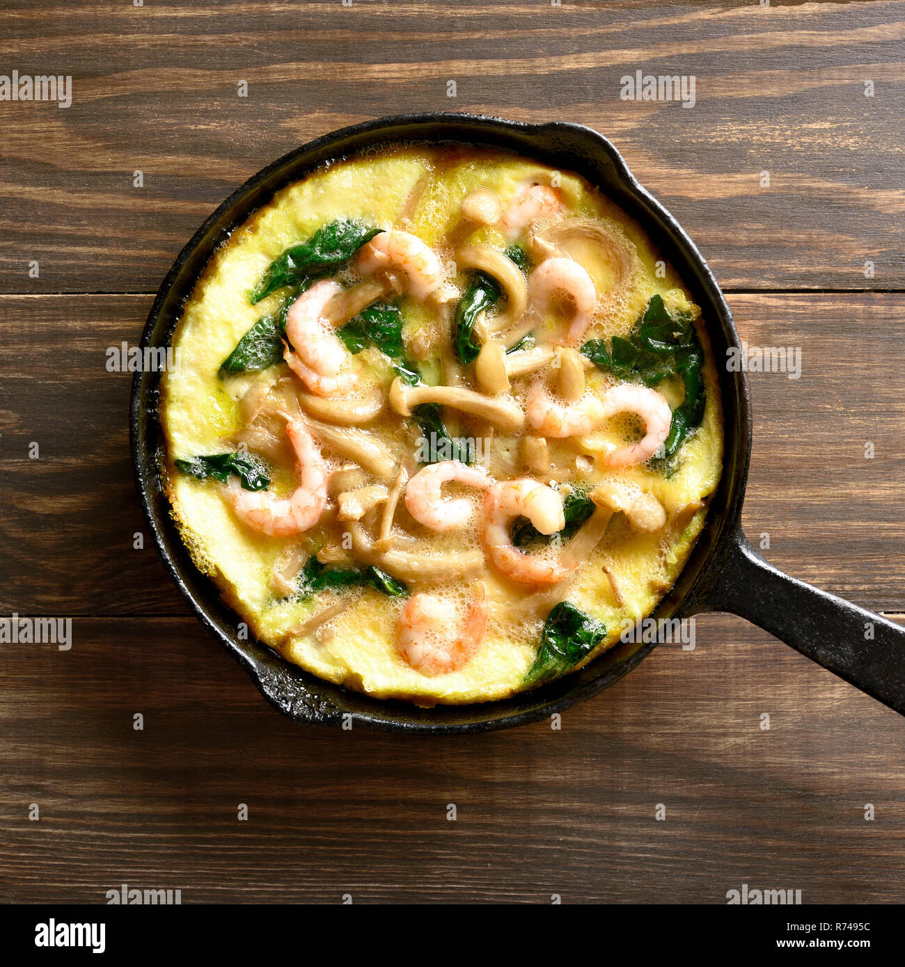 Close up de champignons et épinards frittata aux crevettes à frire sur fond de bois. Haut de la vue, télévision lay Banque D'Images