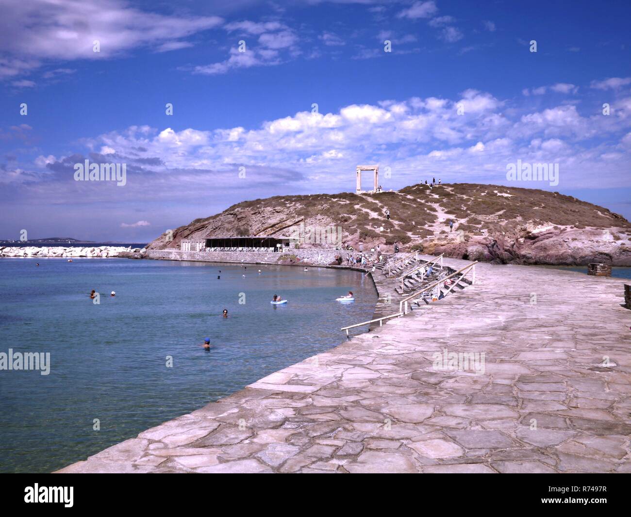 Avis de Portara ou temple d'Apollon sur l'île de Palatia à côté de l'île de Naxos et les gens nager dans la mer Banque D'Images