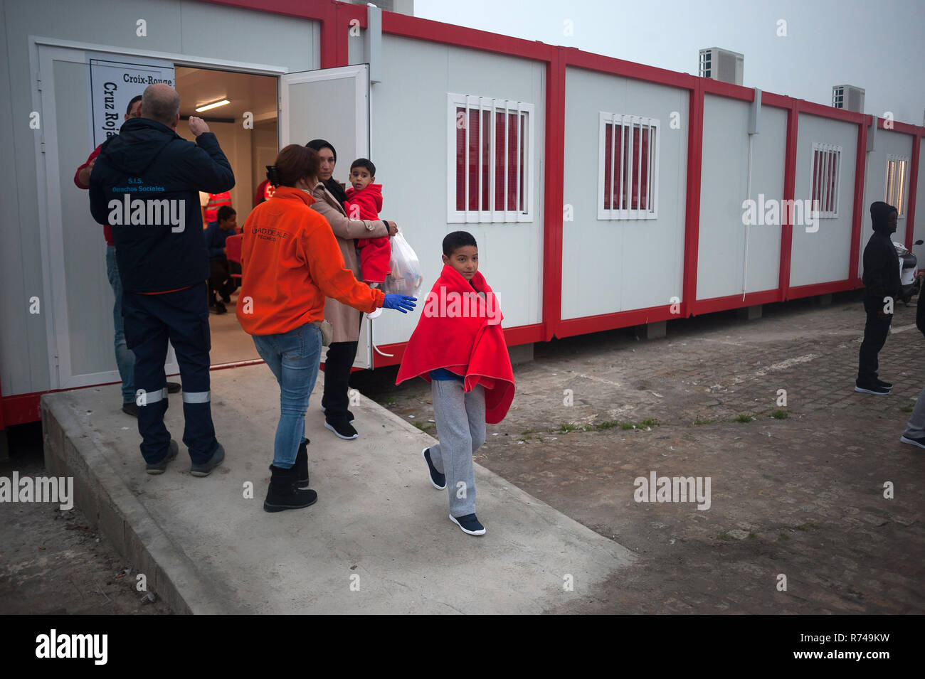 Les enfants de migrants et les femmes sont considérées à la sortie d'un décrochage d'urgence humanitaire après son arrivée au Port de Malaga. Service de Sauvetage Maritime de l'Espagne a sauvé environ 148 migrants à bord des canots à la mer d'Alboran et les apporta à Malaga port où ils étaient assistés par la Croix Rouge Espagnole. Banque D'Images