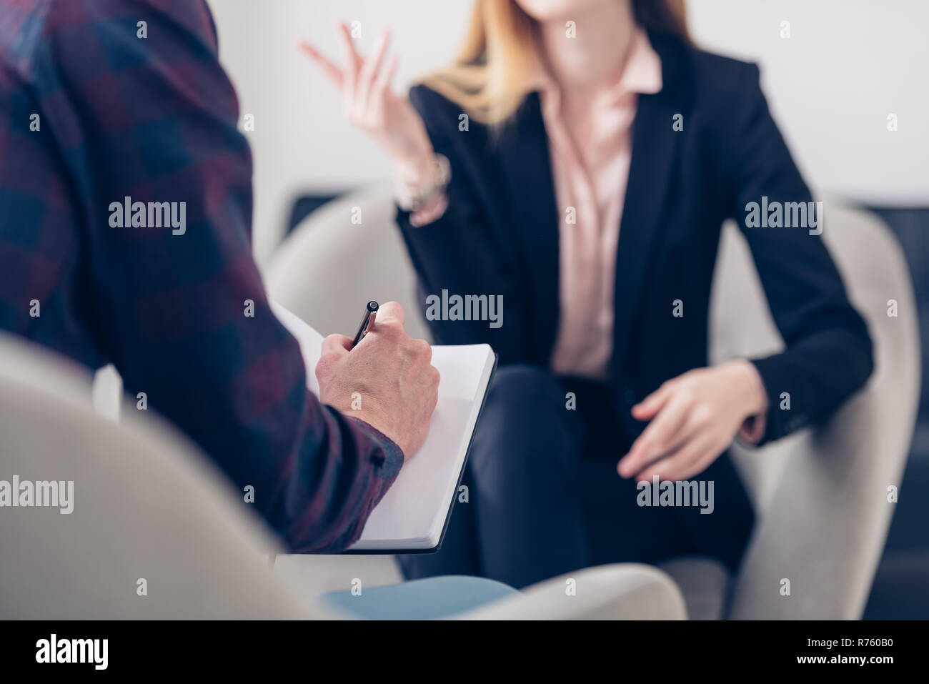 Portrait of businesswoman in suit donnant interview à la journaliste et il prend des notes in office Banque D'Images
