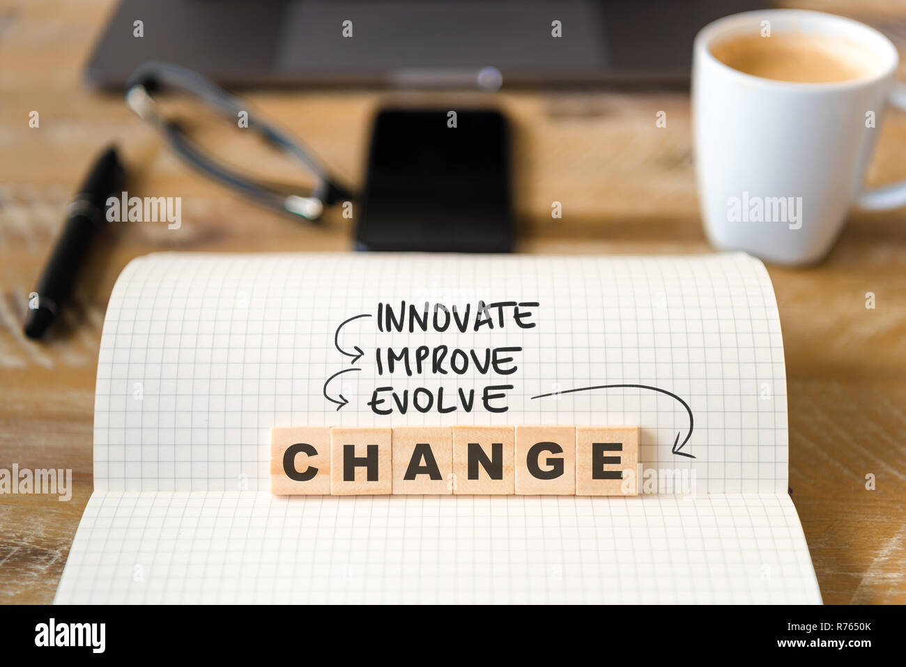 Gros plan sur ordinateur portable sur la table de bois, l'arrière-plan l'accent sur des pièces en bois avec des lettres qui savent innover, améliorer, d'évoluer, de modifier le texte Banque D'Images
