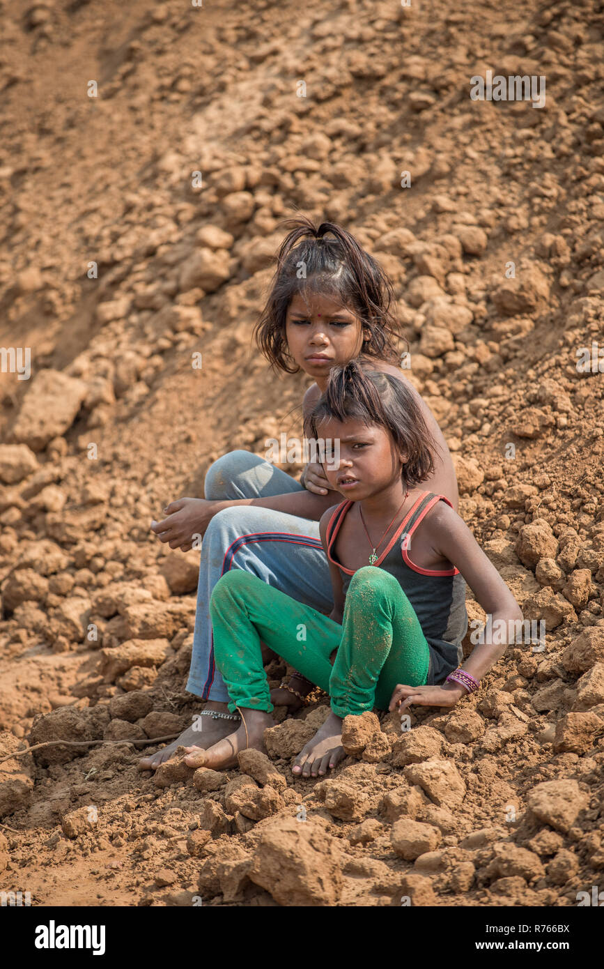 Deux jeunes filles assises sur le terrain dans une fabrique de briques, Rajasthan, Inde Banque D'Images