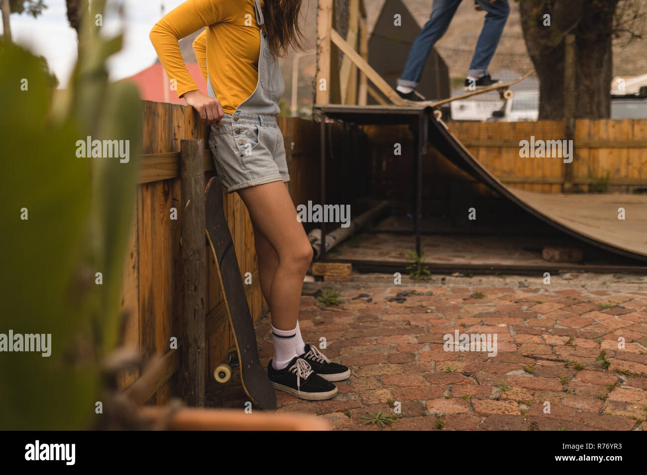 Femme debout avec la planche à roulettes Banque D'Images