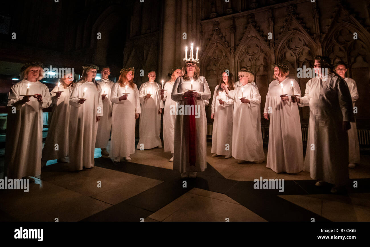 Sarah Evander, portant une couronne de bougies symbolisant St Lucy, conduit une procession aux chandelles du choeur nordique au cours de la London Sankta Lucia service à York Minster. Banque D'Images