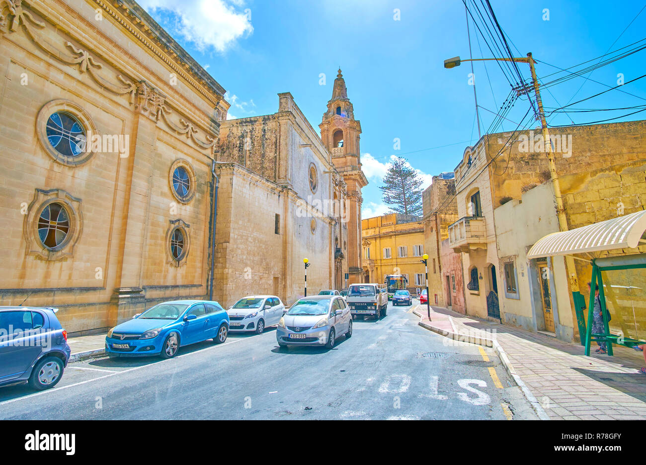 NAXXAR, MALTA - Juin 14, 2018 : le trafic lourd sur l'étroitesse des routes dans une petite ville à côté de l'Église locale, le 14 juin à Naxxar. Banque D'Images