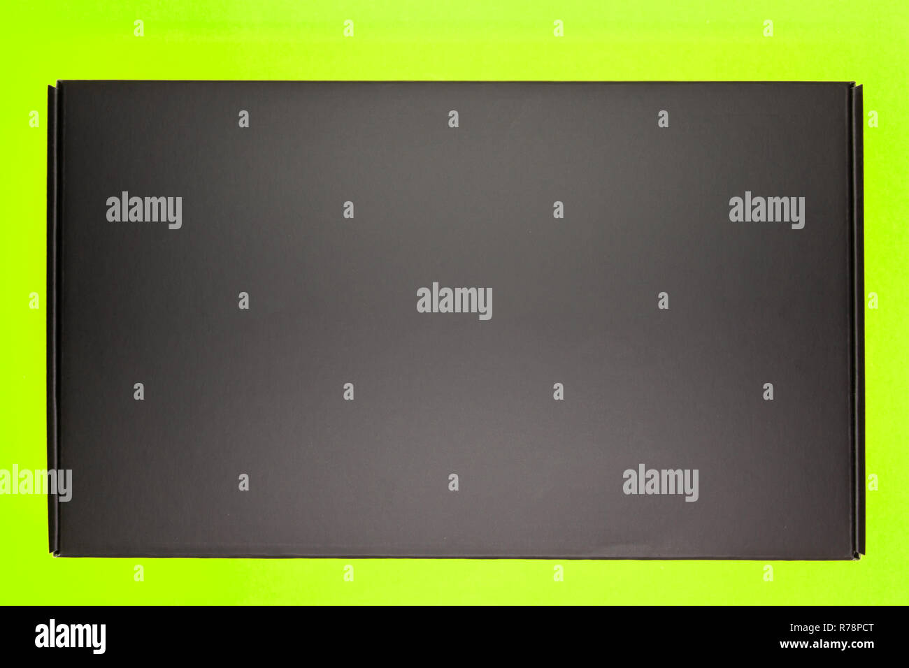 Les boîtes avec des cadeaux pour la maison de vacances enveloppé dans du papier kraft avec des arcs d'or se trouvent sur un fond vert sombre entre confetti Banque D'Images