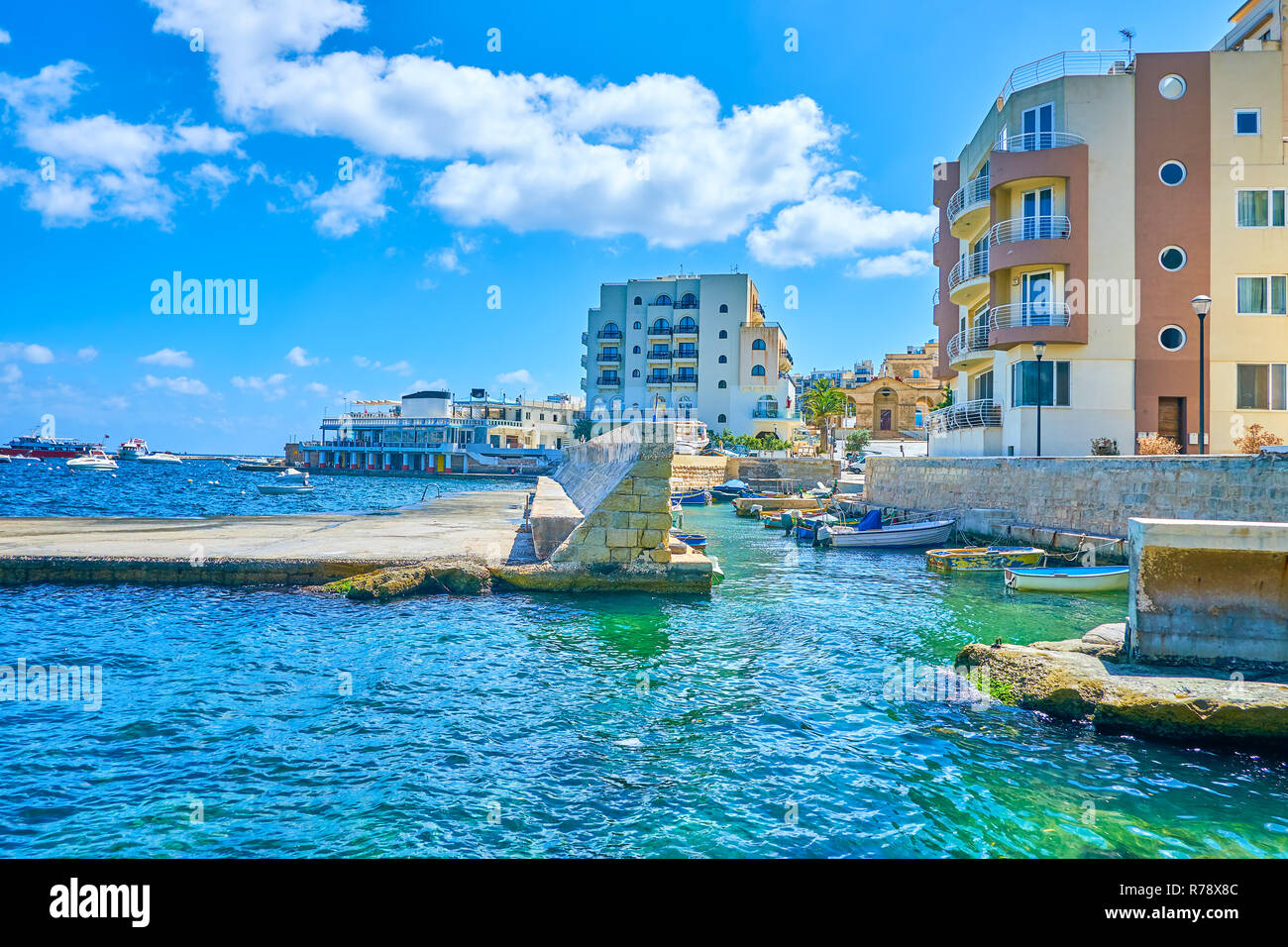 La promenade de bord de mer San Geraldu ouvre la vue sur le port de pêche, entouré par les hôtels touristiques modernes de resort, Bugibba, Saint Paul Bay, Malte. Banque D'Images