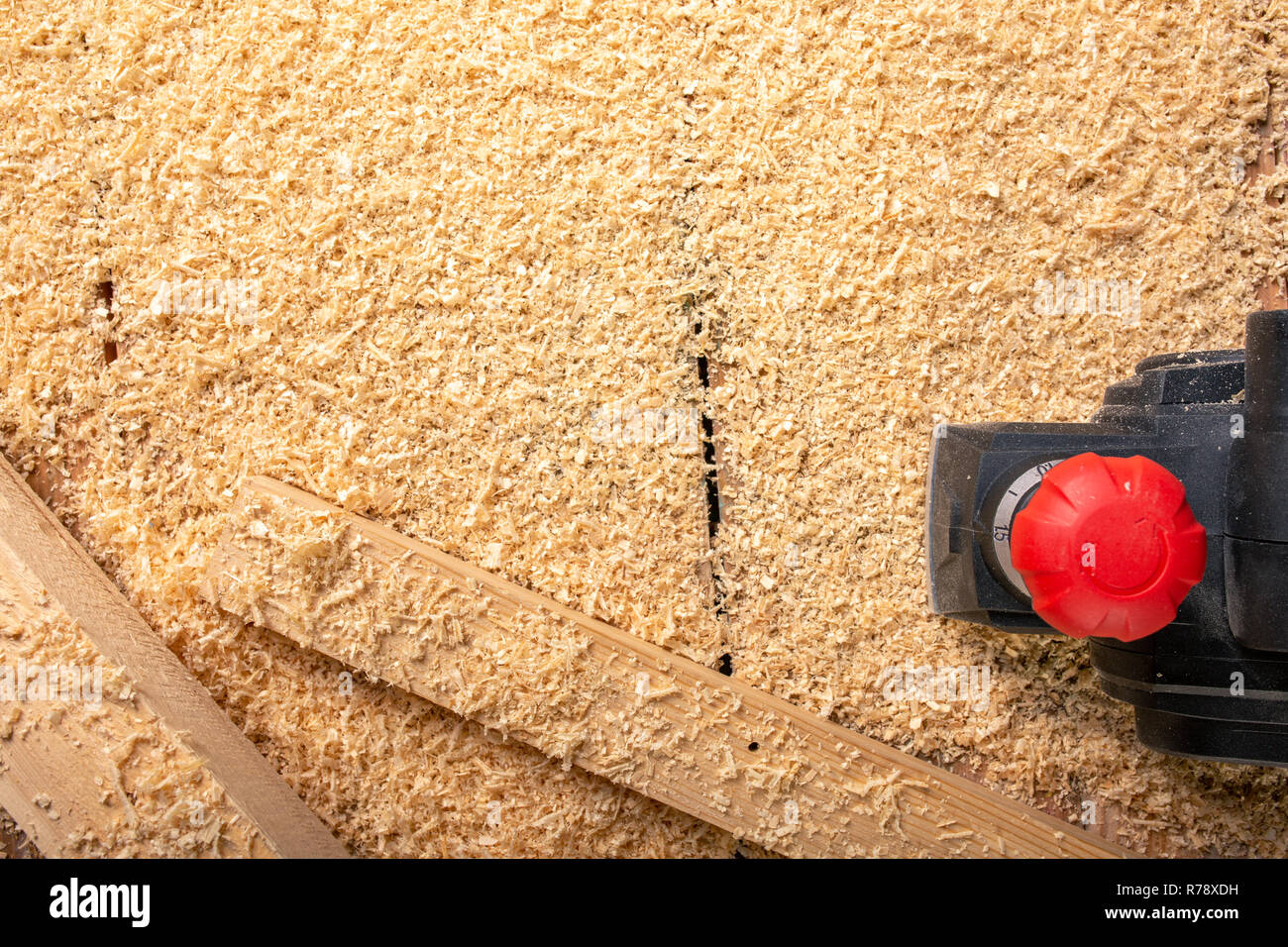 La ponceuse électrique sur un backgroundshavings bois Banque D'Images