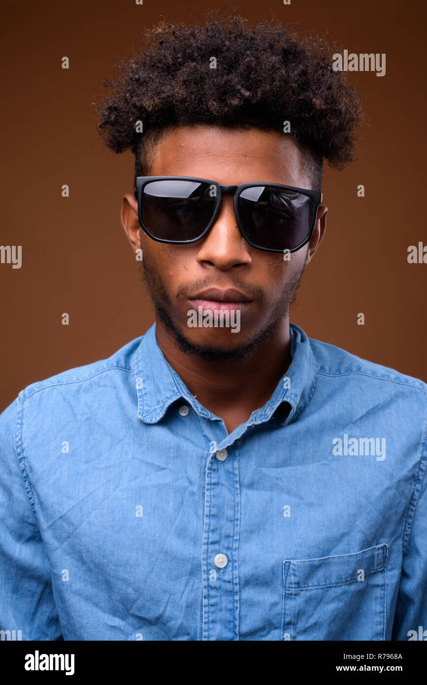 Portrait of young handsome African man wearing sunglasses Banque D'Images