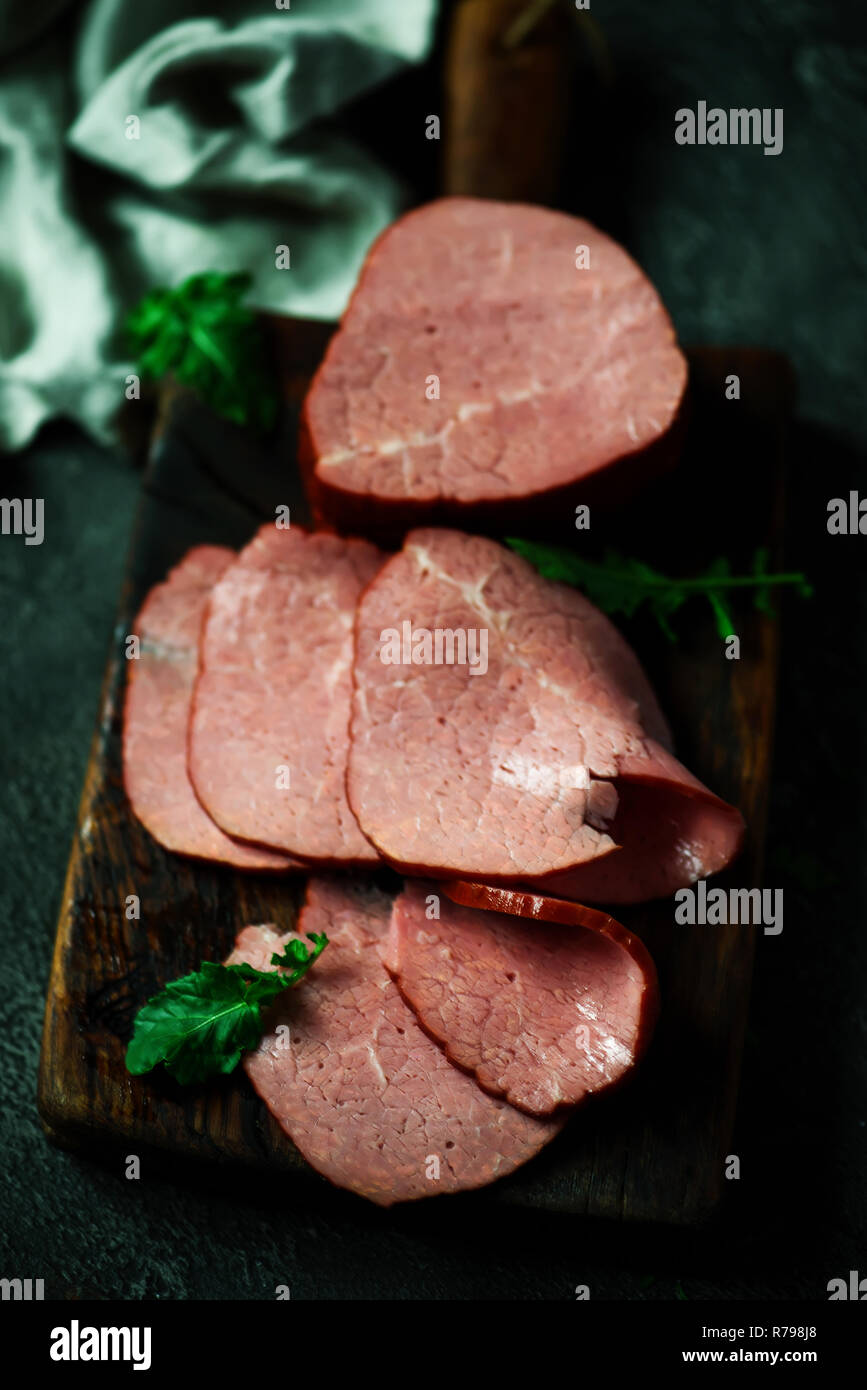 La coupe d'un boeuf fumé sur une planche à découper. Rustique de style. Selective focus Banque D'Images