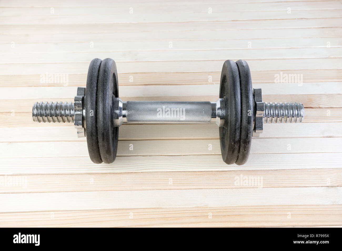 Black metal gym haltère avec chrome poignée d'argent sur fond de bois à haute résolution. concept de perte de forme physique et de poids. Banque D'Images