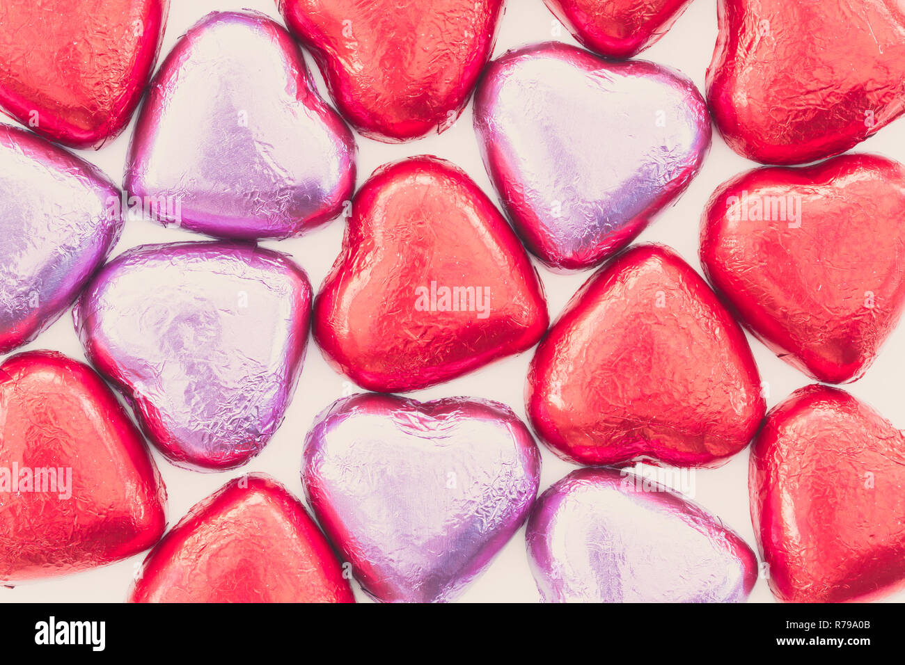 Une image complète de l'arrière-plan du chocolat ou des bonbons coeurs roses et rouges enveloppé dans du papier et prêt pour l'amour le jour de Valentines comme cadeau ou présent avec l'exemplaire. Banque D'Images
