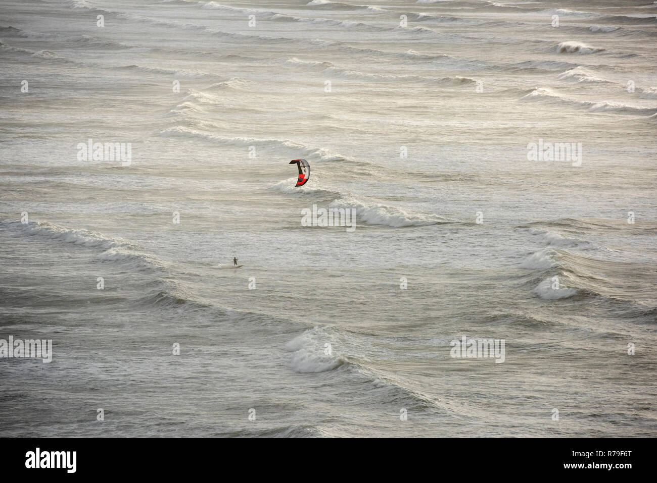 Un Kite surfer en mer agitée et les vagues au large de la côte du Devon UK Banque D'Images