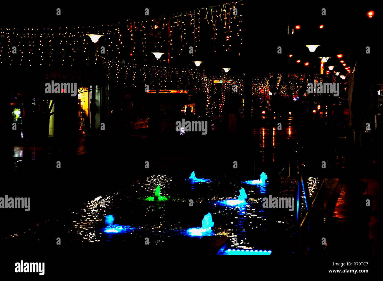 Nuit rue de la ville est décorée d'une guirlande lumineuse et une fontaine avec éclairage. Décoration de la ville d'Israël pour le nouveau Y et Hanukkah Banque D'Images