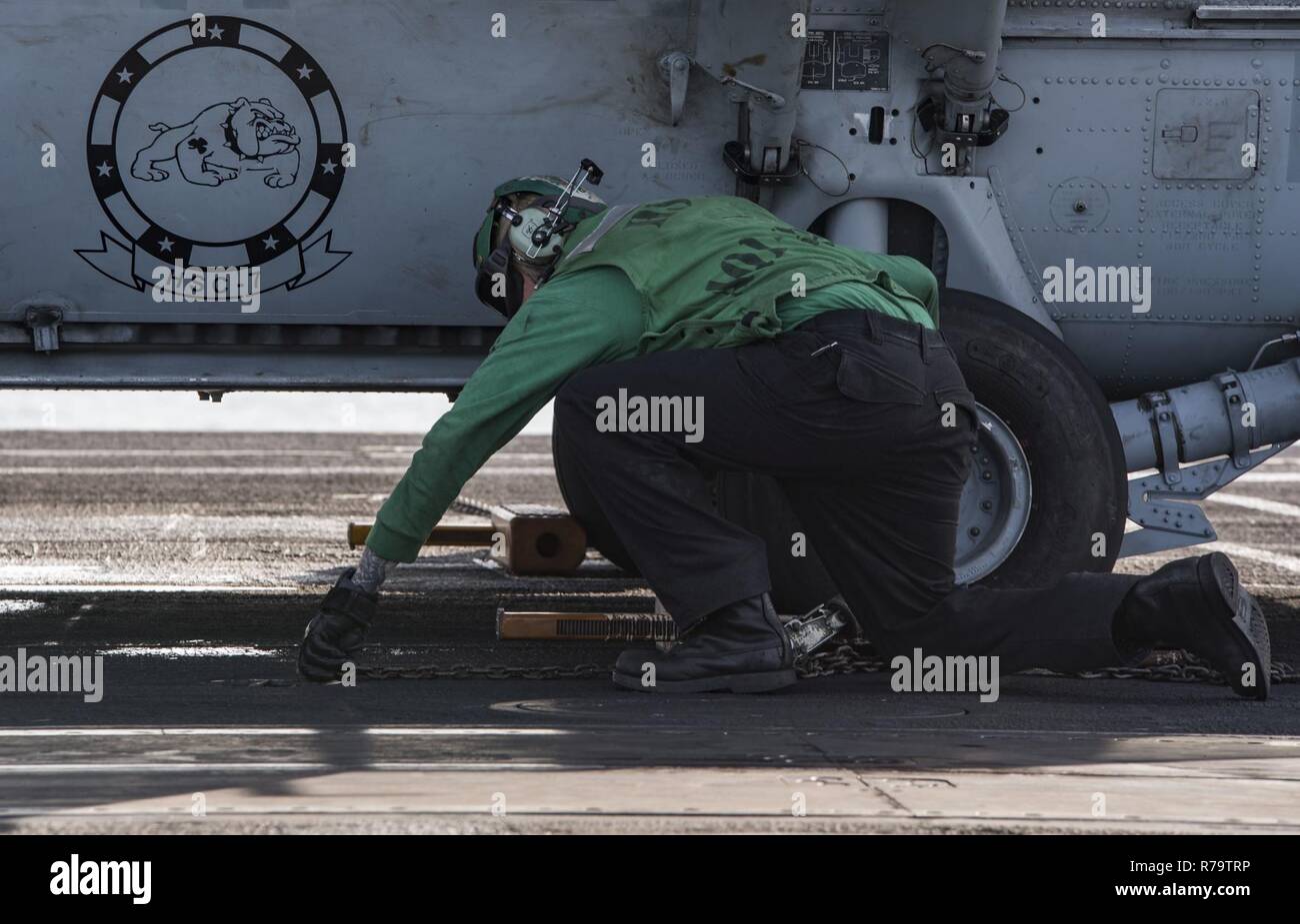 Océan Atlantique (12 avril 2017) l'Aviation-électricien 2e classe Daniel Henson, de Austin, Texas, supprime les chaînes et des cales d'un MH-60S Sea Hawk affecté à l'hélicoptère de chiens poussiéreux de l'Escadron de Combat de mer (HSC) 7 sur le pont d'envol du porte-avions USS Dwight D. Eisenhower (CVN 69) (Ike). Ike et son groupe aéronaval sont en cours participant à un exercice de soutien conçus pour maintenir la disponibilité du déploiement dans le cadre du Plan d'intervention de la flotte optimisée (OFRP). Banque D'Images