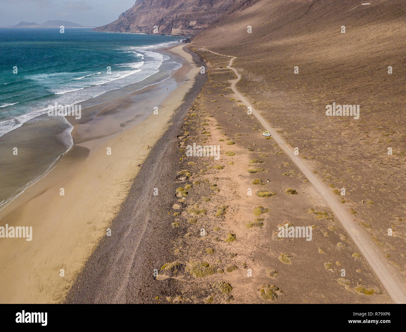 Vue aérienne de la plage de Famara, Lanzarote, îles Canaries, Espagne. Di Risco de Famara, relief, montagne surplombant l'océan Atlantique. Chemin de terre Banque D'Images