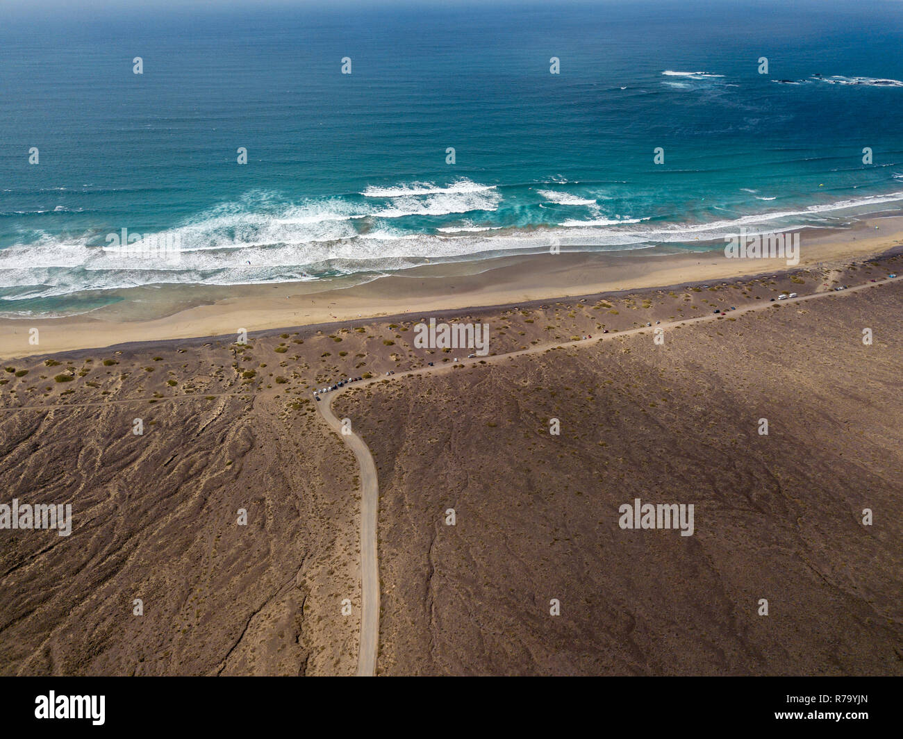 Vue aérienne de la plage de Famara, Lanzarote, îles Canaries, Espagne. Risco de Famara, relief, montagnes surplombant l'océan Atlantique. Chemin de terre Banque D'Images