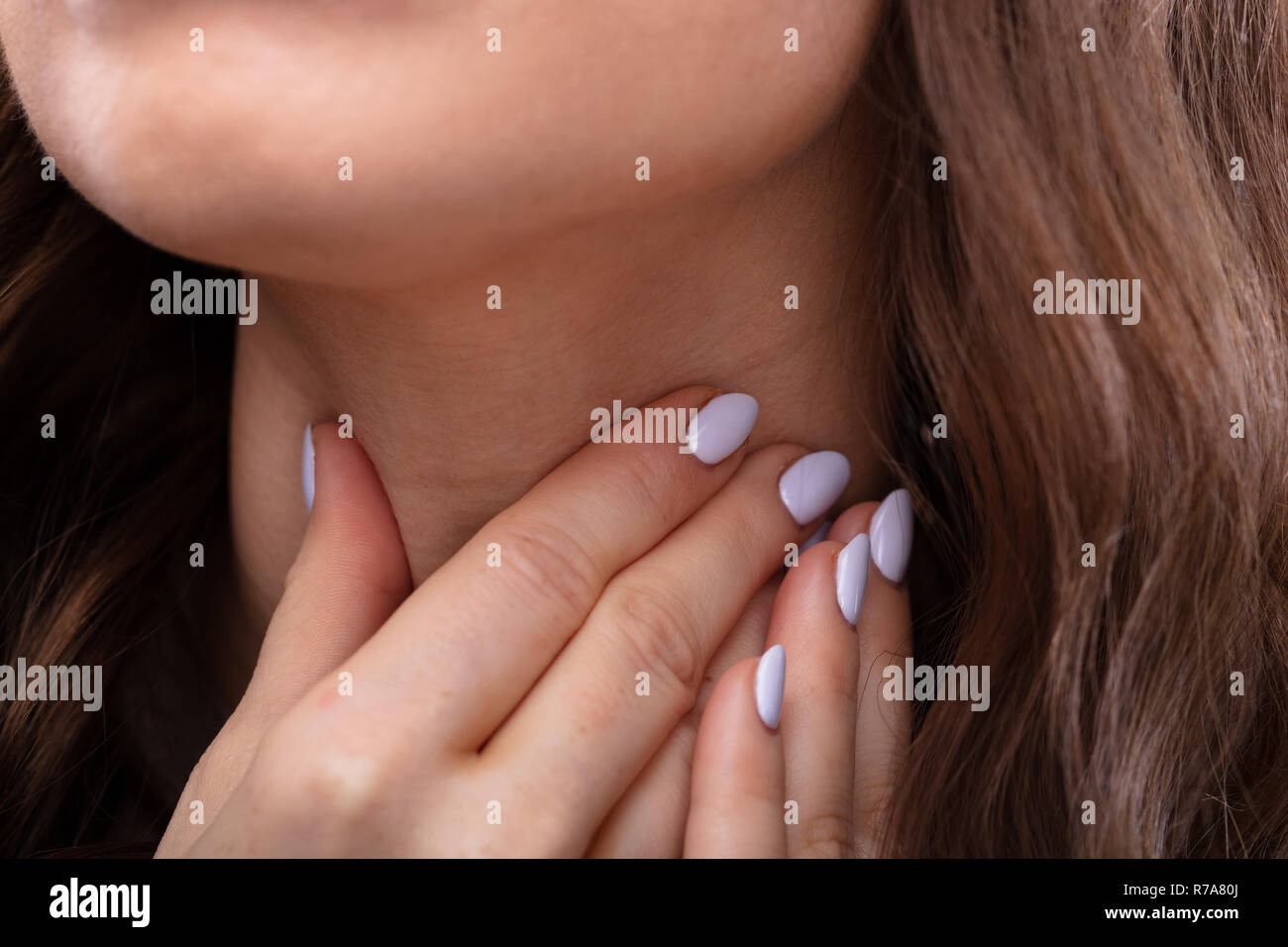 Close-up of a Woman's Hand Touching son mal de gorge Banque D'Images