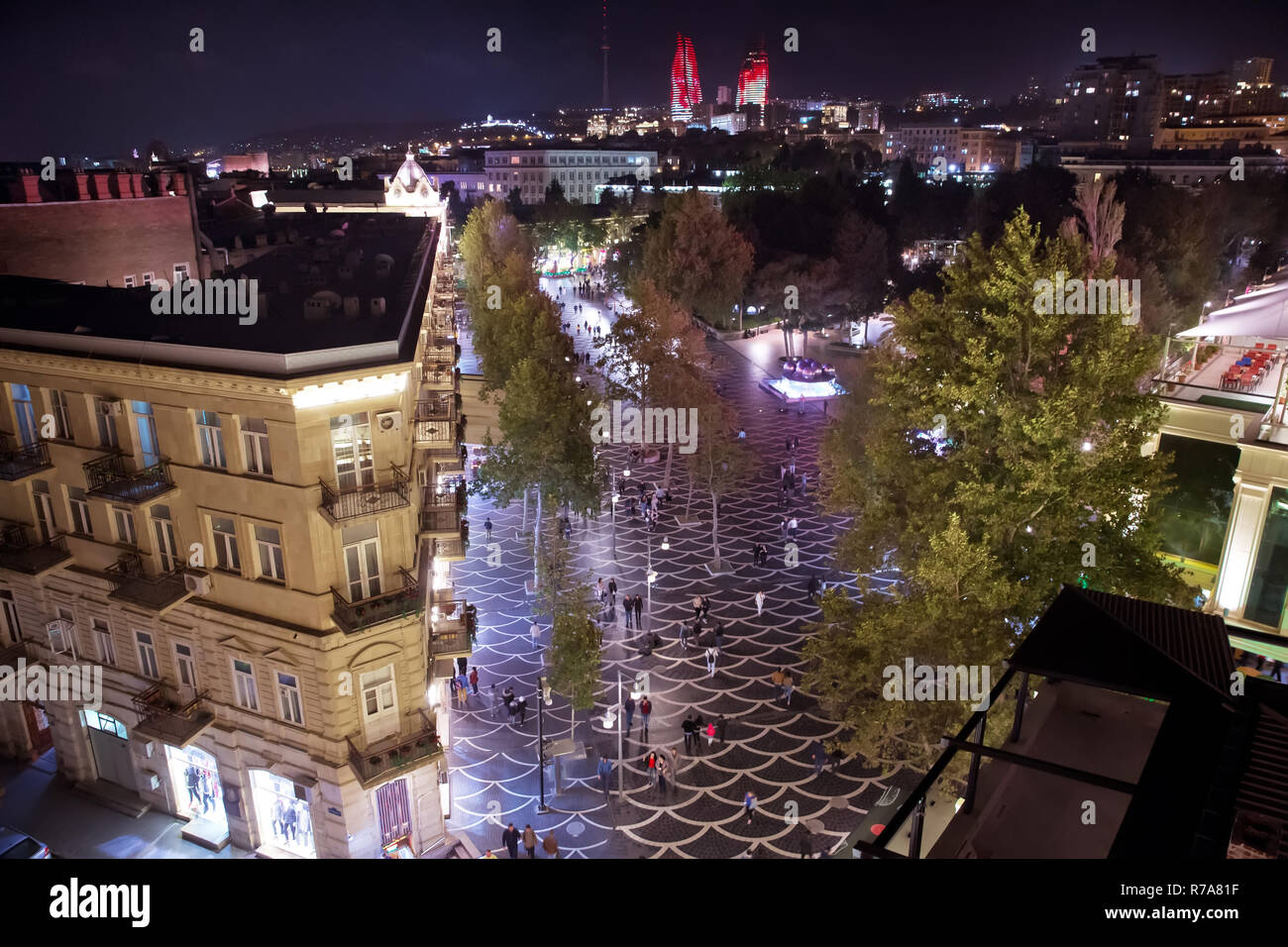 Il est suspendu un lustre entre les maisons sur la rue. Nizami Street avec un éclairage de nuit. Centre commercial de Bakou . Les gens marchent dans la rue Nizami Banque D'Images