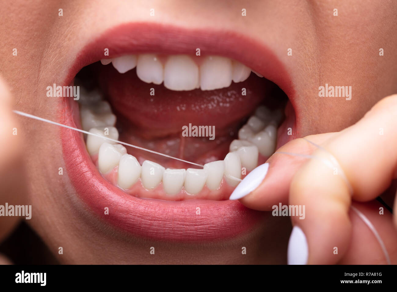Close-up of a Woman's Hand Soie dentaire Les dents Banque D'Images