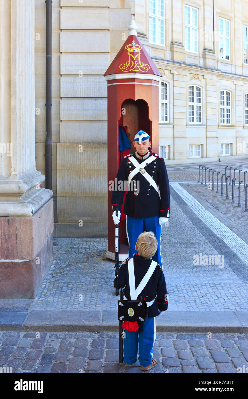 Une vie Royal Guard à la monarchie danoise de service devant sa guérite et petit garçon à l'extérieur le Palais d'Amalienborg à Copenhague, Danemark Banque D'Images