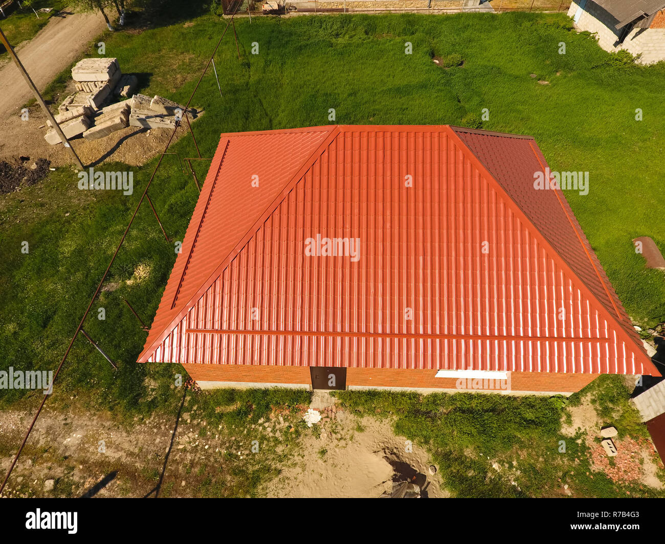 Maison avec un toit orange en métal, vue d'en haut. Profil métallique ondulé peint sur le toit. Banque D'Images