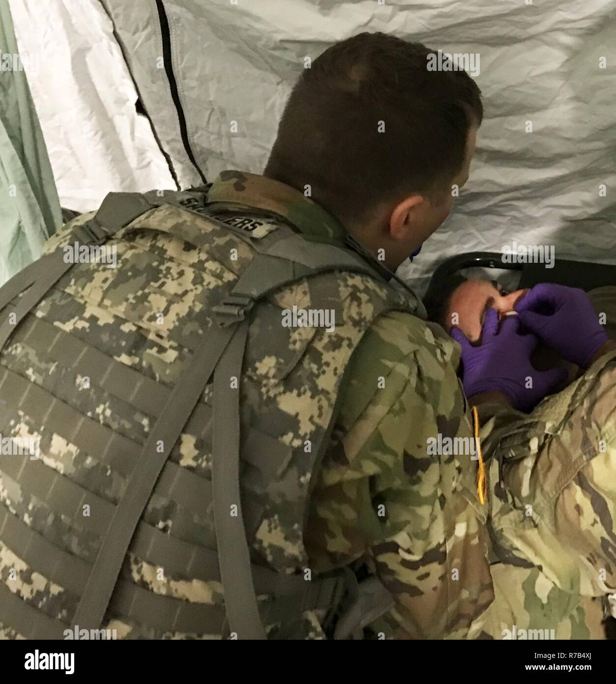 Deux soldats administrer une aide médicale à un soldat avec une blessure à l'œil dans Charlie Med, la Compagnie C, 113e Bataillon de soutien de la Brigade d'infanterie, 76e Brigade Combat Team au cours de l'exercice d'entraînement de printemps en préparation pour Joint Readiness Training Center, rotation # JRTC, plus tard cet été. ( Banque D'Images