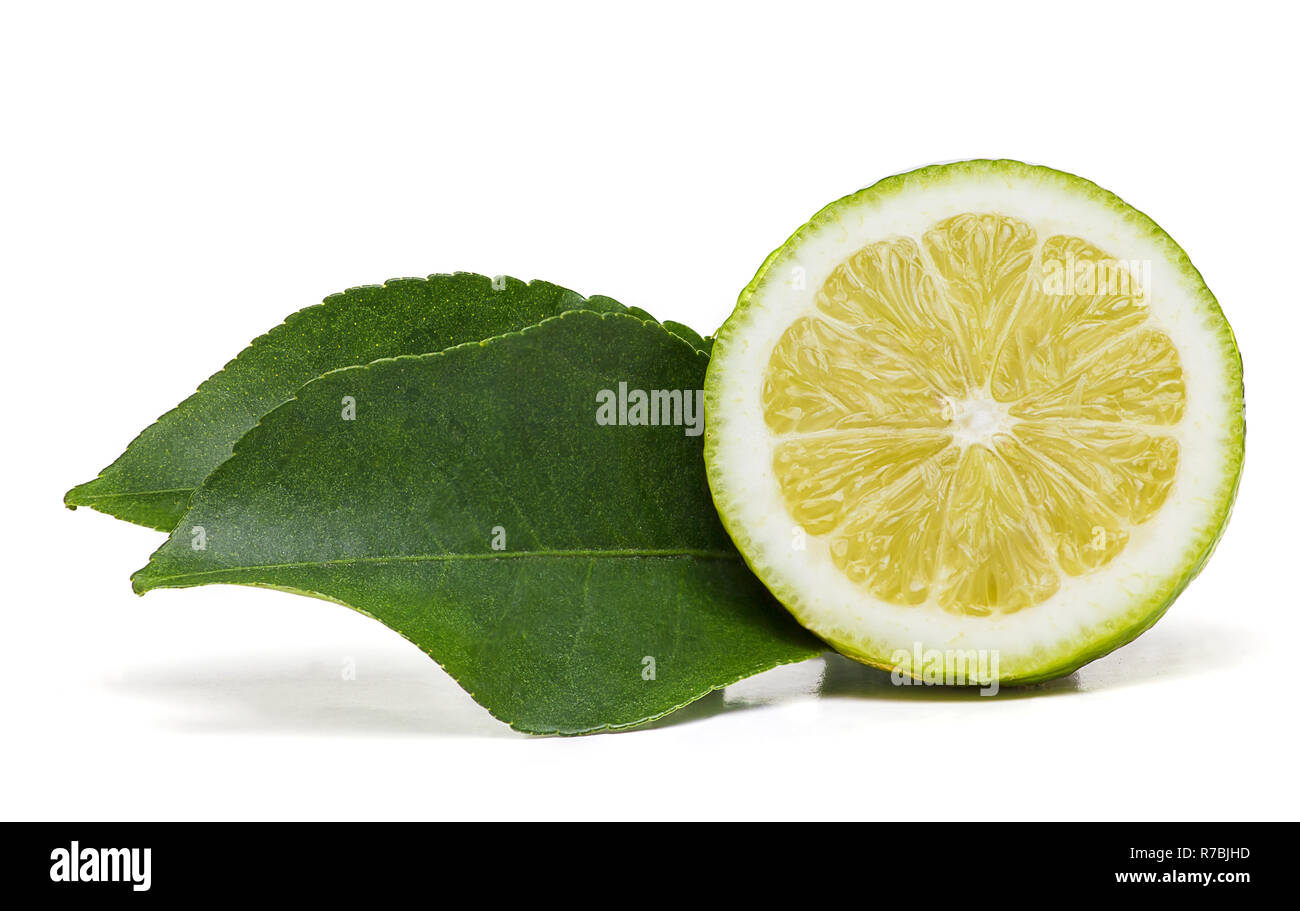 Demi-citron fruit avec deux feuilles vertes sur le côté isolé sur un fond Banque D'Images