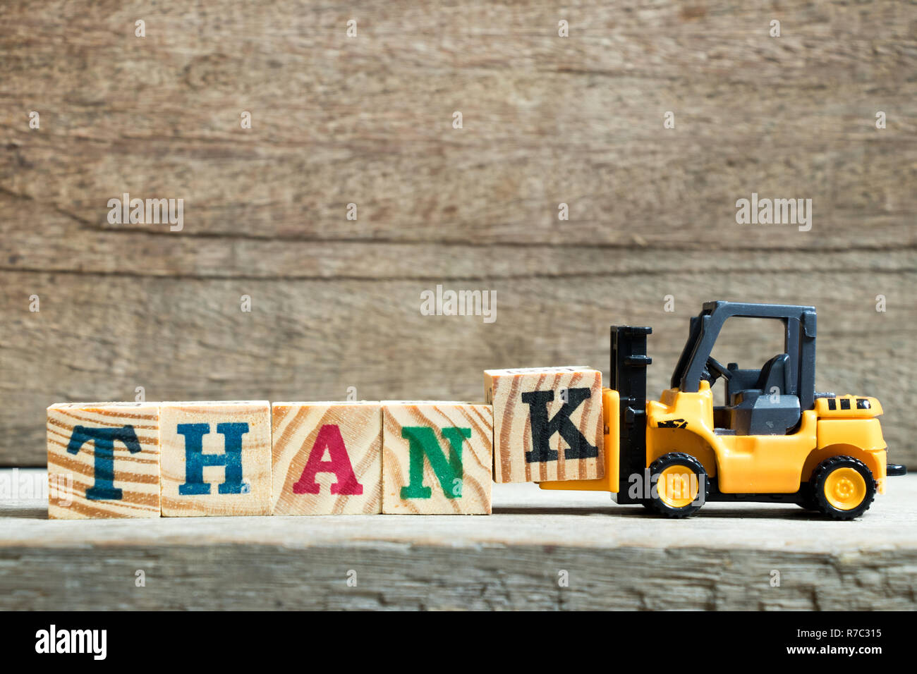 Jouet chariot jaune lettre K pour maintenir le bloc de texte sur fond de bois merci Banque D'Images