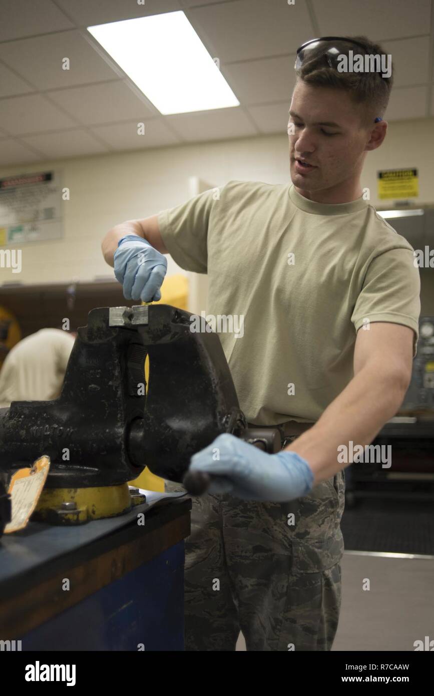 Les cadres supérieurs de l'US Air Force Airman Joshua Cox, 18e Escadron de maintenance des composants technicien hydraulique moyenne pression, resserre un flexible en caoutchouc, 2 mai 2017 L'Assemblée générale, à Kadena Air Base, au Japon. Les aviateurs de l'hydraulique s'appuient souvent sur plusieurs quarts afin de terminer les réparations dans un délai raisonnable, comme le fait d'avoir une équipe de démontage et inspection d'une part et l'équipe suivante remontage et essai de l'article. Banque D'Images