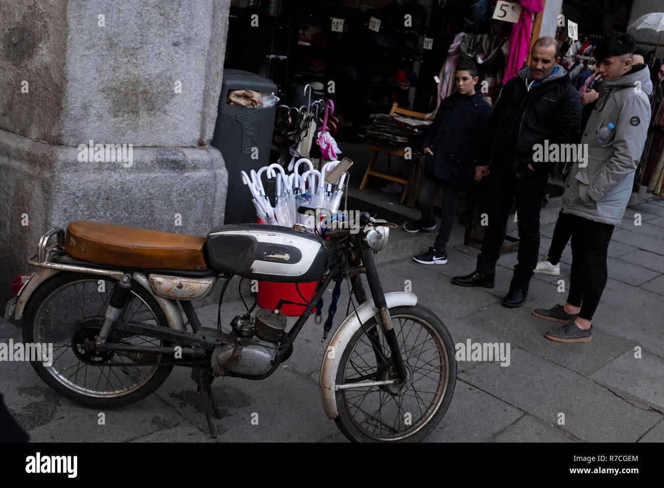 Un groupe de personnes regarder une vieille moto dans une rue de Madrid Banque D'Images