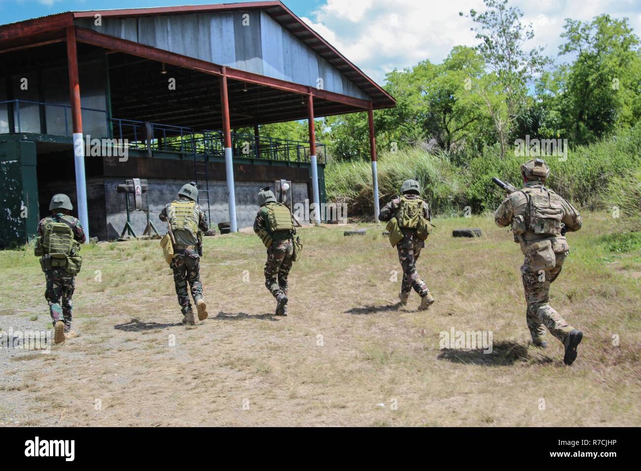 Les Forces armées des Philippines, Soldats Joint Special Operations Group, et des soldats américains, 1er Bataillon, 1st Special Forces Group, rush un bâtiment en close quarters battle formation à l'appui de Balikatan 2017 au Fort Magsaysay à Santa Rosa, Nueva Ecija, 12 mai 2017. Par la formation, l'ensemble des Philippines et de l'armée américaine s'appuyer sur des tactiques, des techniques et des procédures qui améliorent les capacités de préparation et de réponse aux menaces émergentes. Balikatan est un américain annuel-exercice militaire bilatérale des Philippines a porté sur une grande variété de missions, y compris l'aide humanitaire et des secours, Banque D'Images