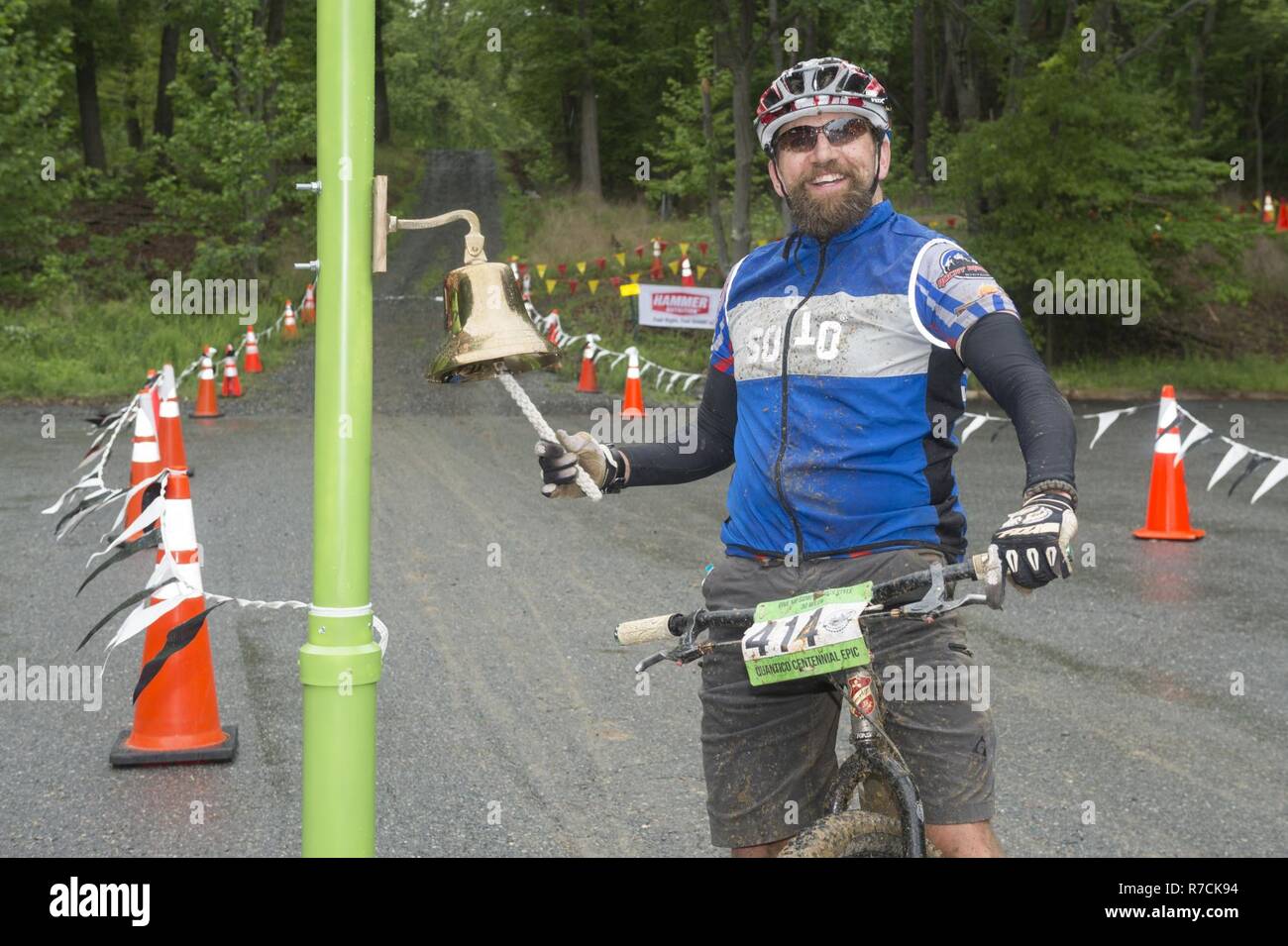 Un participant sonne une cloche après l'épopée du Centenaire en vélo de montagne, à travers les sentiers dans le Marine Corps Base (MCB) Quantico, en Virginie, le 6 mai 2017. Organisé par le Club de vélo de montagne Quantico Marine Corps et les services communautaires, le trajet a été organisée pour célébrer le 100e anniversaire de la MCB Quantico et a également fourni une partie avec de la nourriture, des boissons et de la musique. Banque D'Images