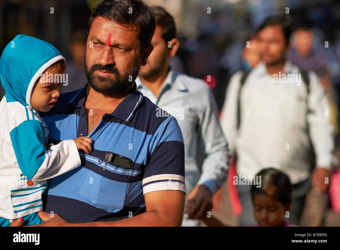 Un Indien avec son jeune fils passant à travers la zone de marché à Mumbai, Inde Banque D'Images