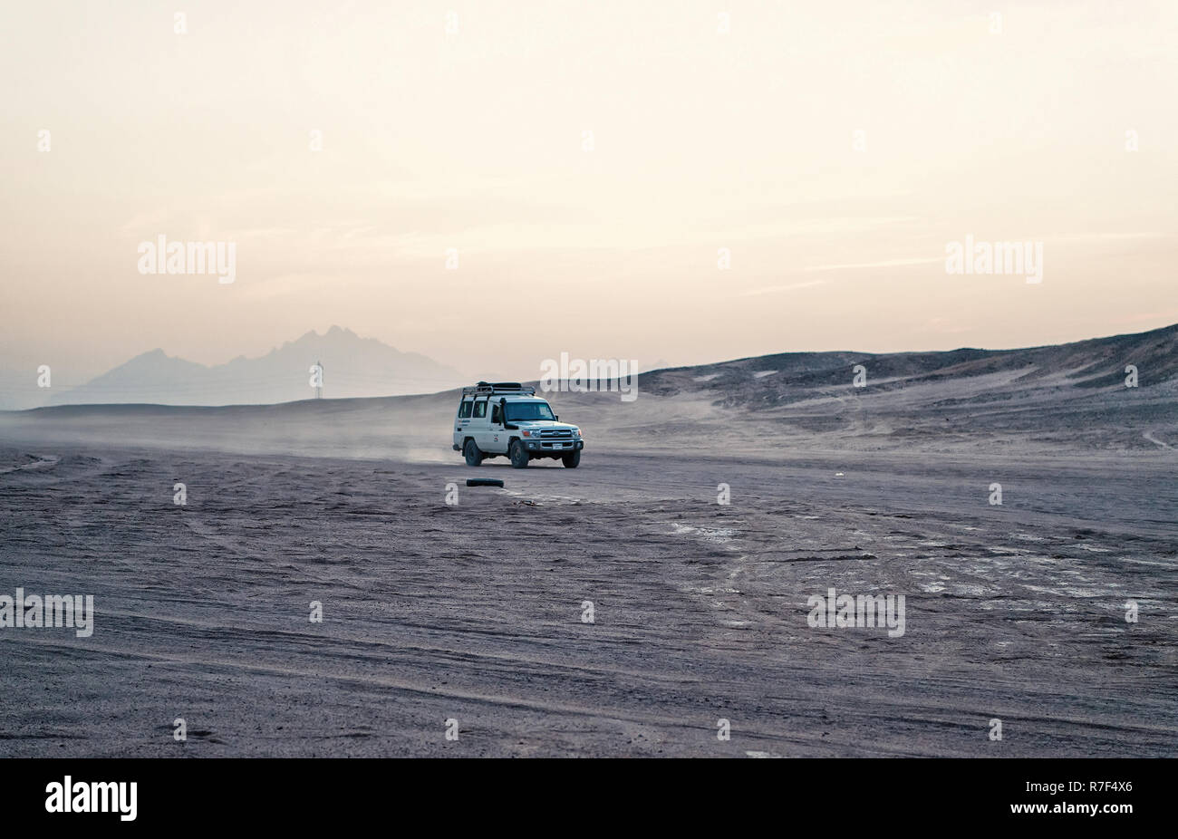 Hurghada, Egypte - Février 26, 2017 : voiture ou jeep, véhicule tout terrain, la conduite dans les dunes de sable du désert, sur fond de ciel blanc en surface. Safari et l'aventure. Voyage, voyage. Paysage aride Wanderlust Banque D'Images