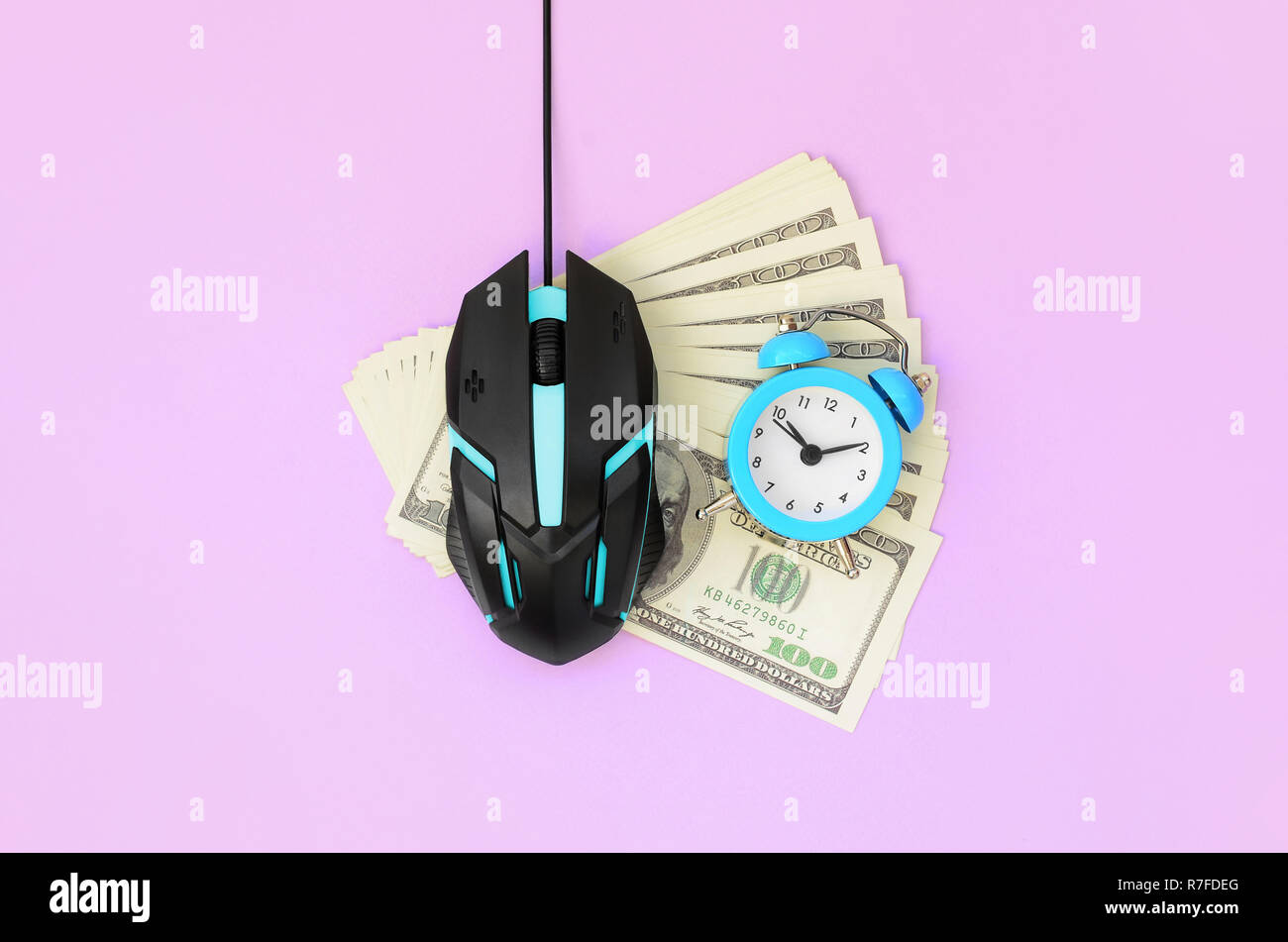 Souris d'ordinateur et petit réveil bleu sur de nombreux billets d'un dollar. Salaire par clic et autoclicker concept. Le bénéfice sur l'Internet. Vue supérieure mise à plat Banque D'Images