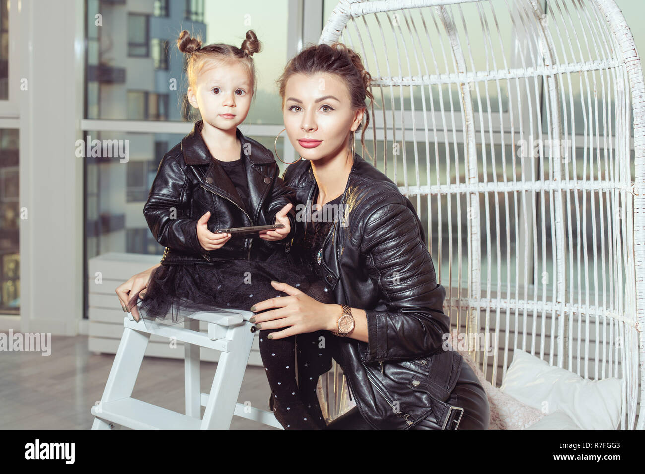 Portrait d'une jeune mère et sa fille dans des vêtements noirs. Banque D'Images