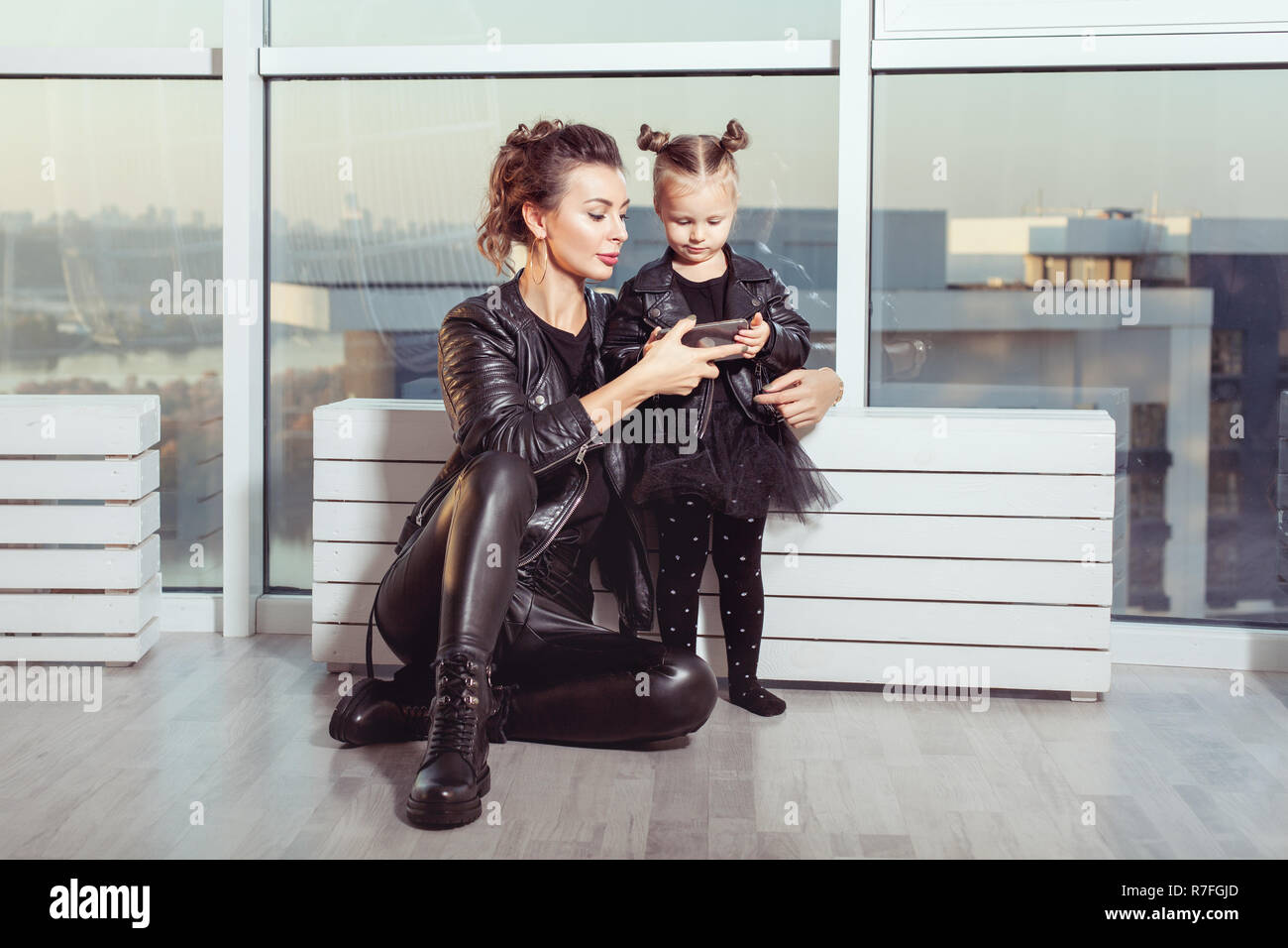 Portrait d'une jeune mère et sa fille. Ils regardent dans le smartphone. Banque D'Images