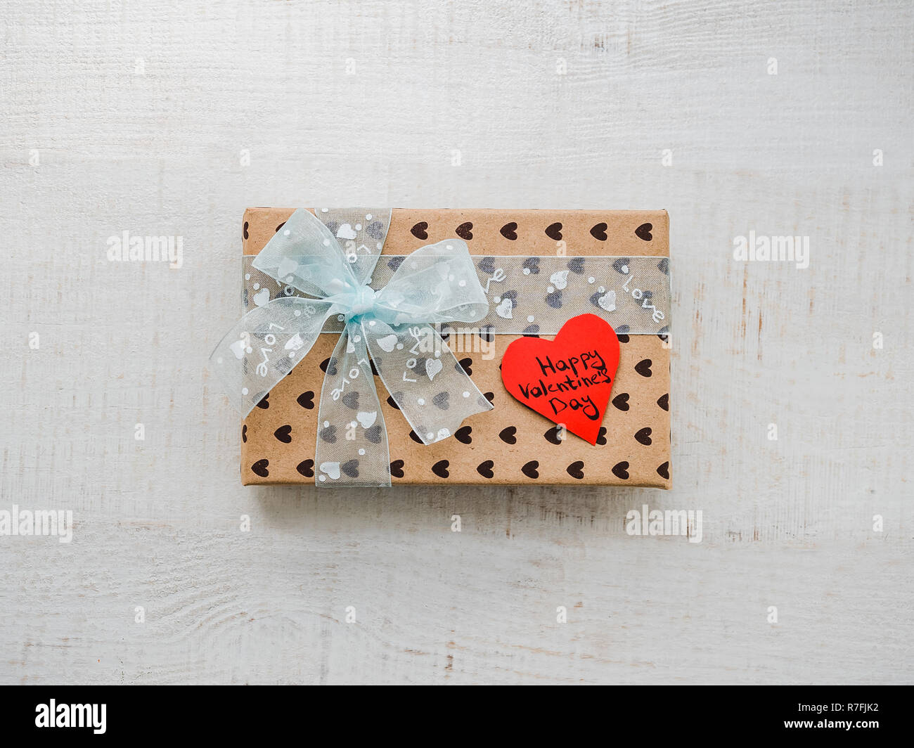 Boîte avec un cadeau, attaché avec un ruban, note avec des mots doux Banque D'Images