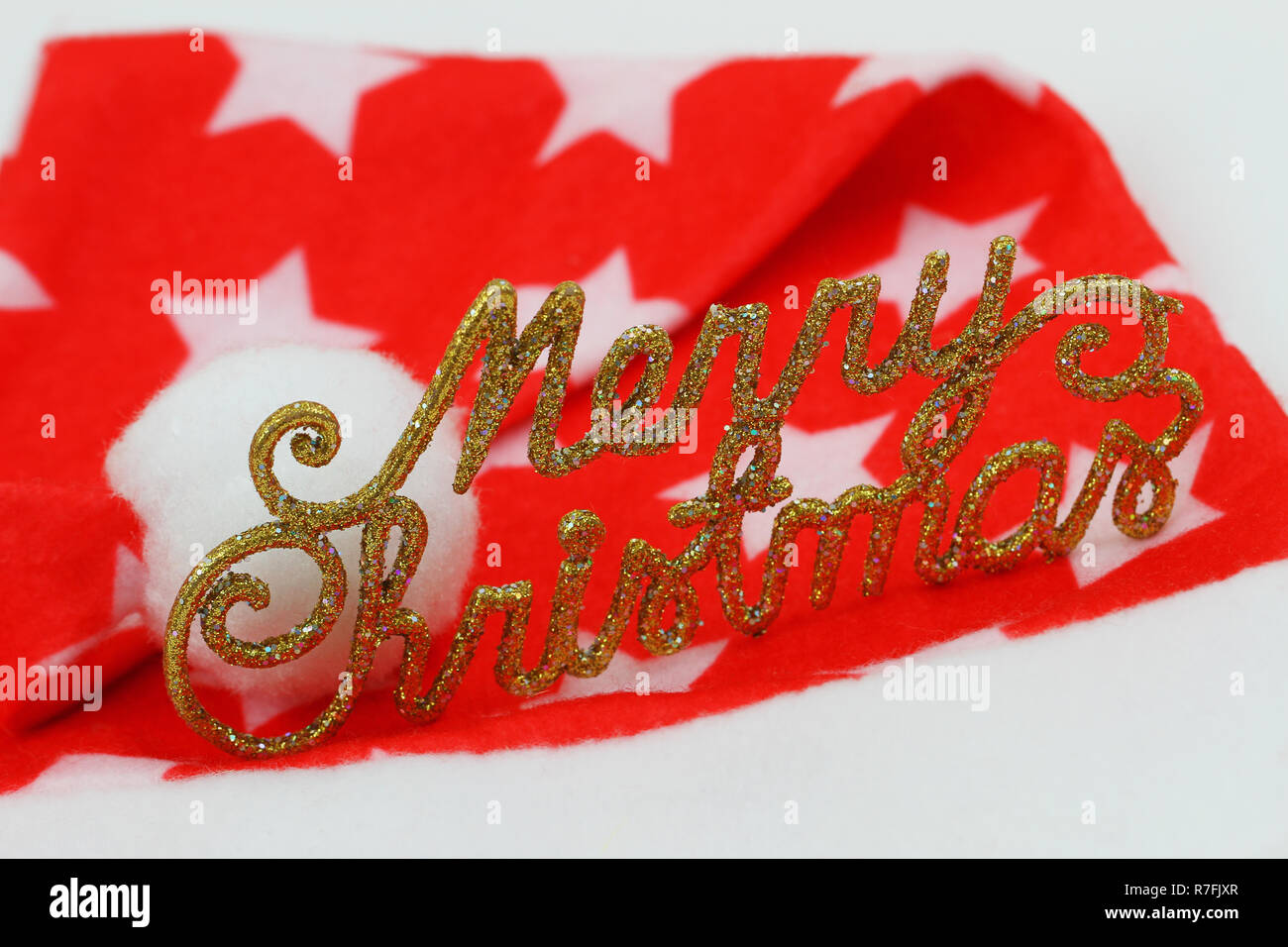 Joyeux Noël écrit en lettres d'or et rouge et blanc bonnet de Noël Banque D'Images
