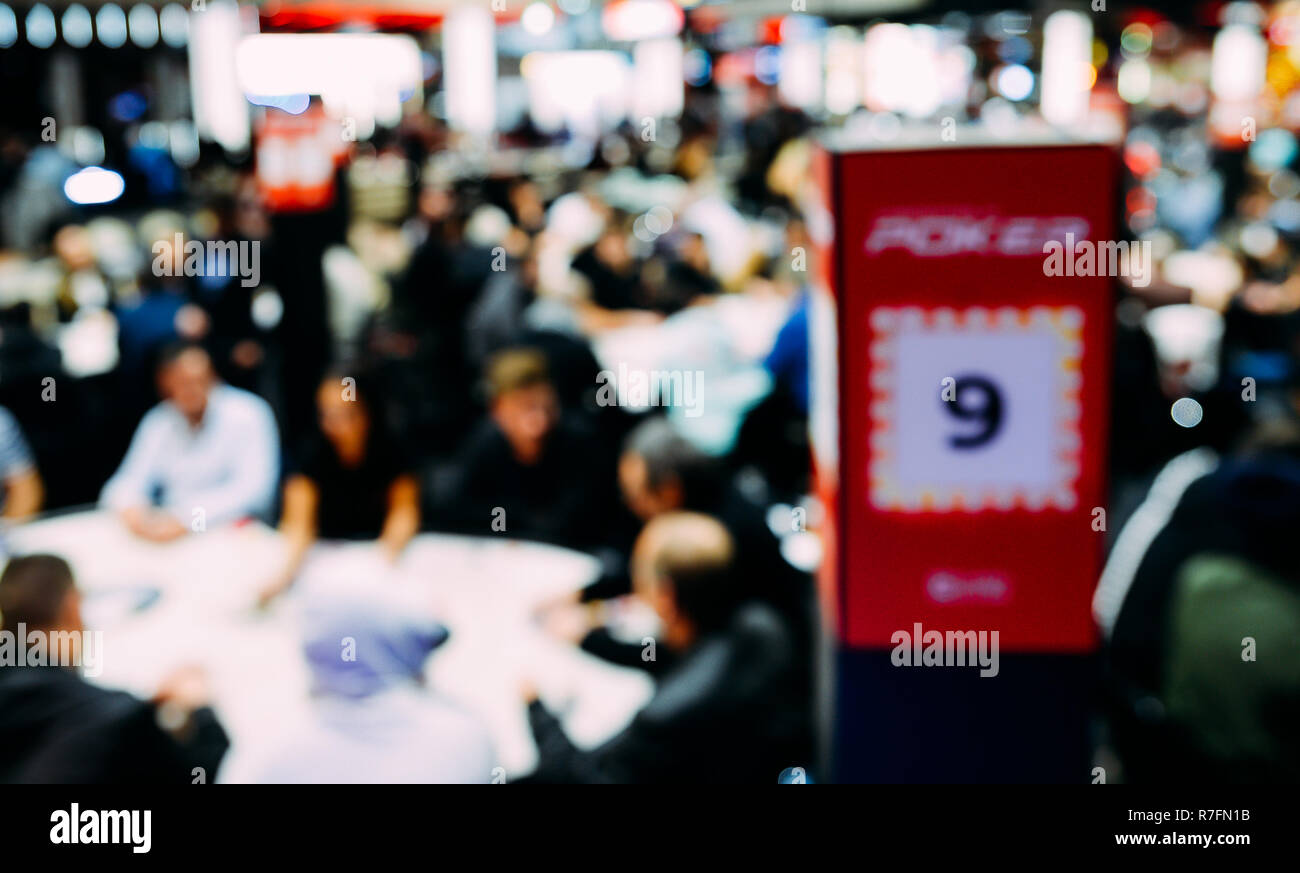 Flou artistique délibérément de voir grand tournoi de poker à tables multiples. Les joueurs assis à table et les concessionnaires s'occupant des cartes. Tournoi de grand champ Banque D'Images