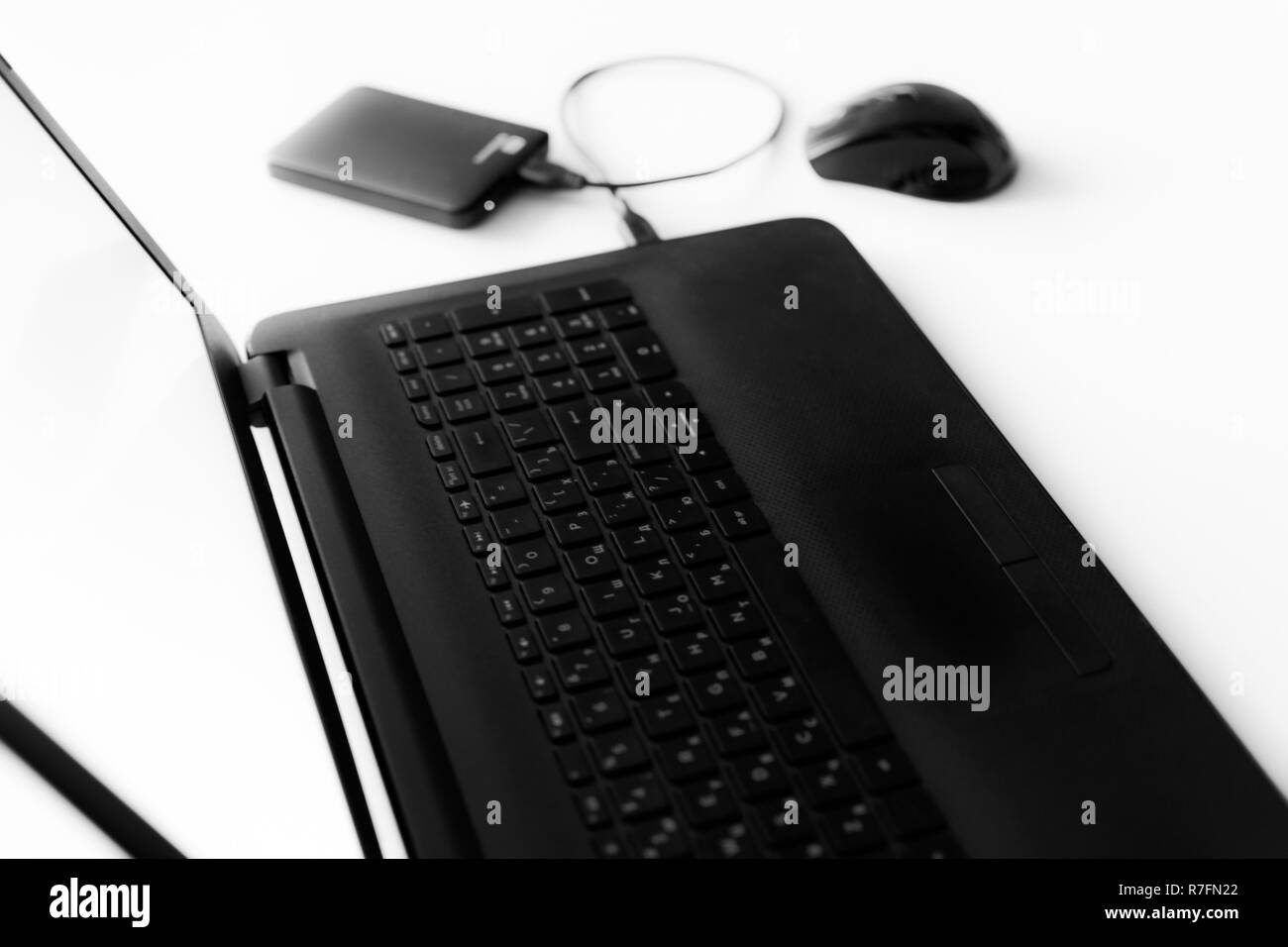 Disque dur pour ordinateur portable noir et blanc de la souris sur le bureau est floue. Banque D'Images