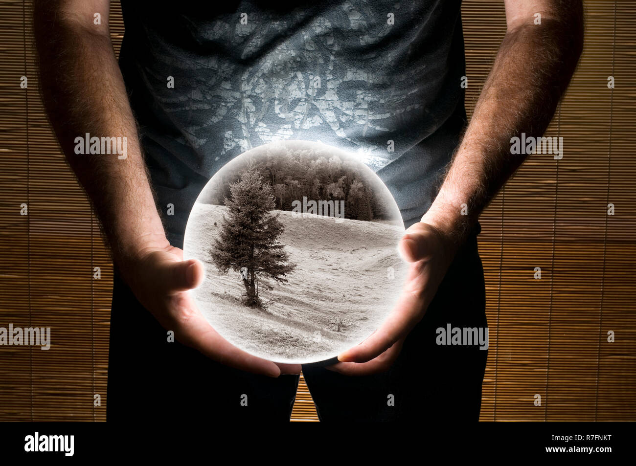 Man holding sphère blanche avec l'intérieur de paysage sépia Banque D'Images